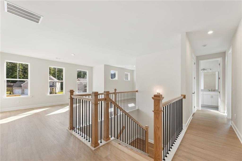 Elegant open staircase with wood treads and black railings in The Hampton C 4-bedroom home, Davidson Homes, Buford, Georgia