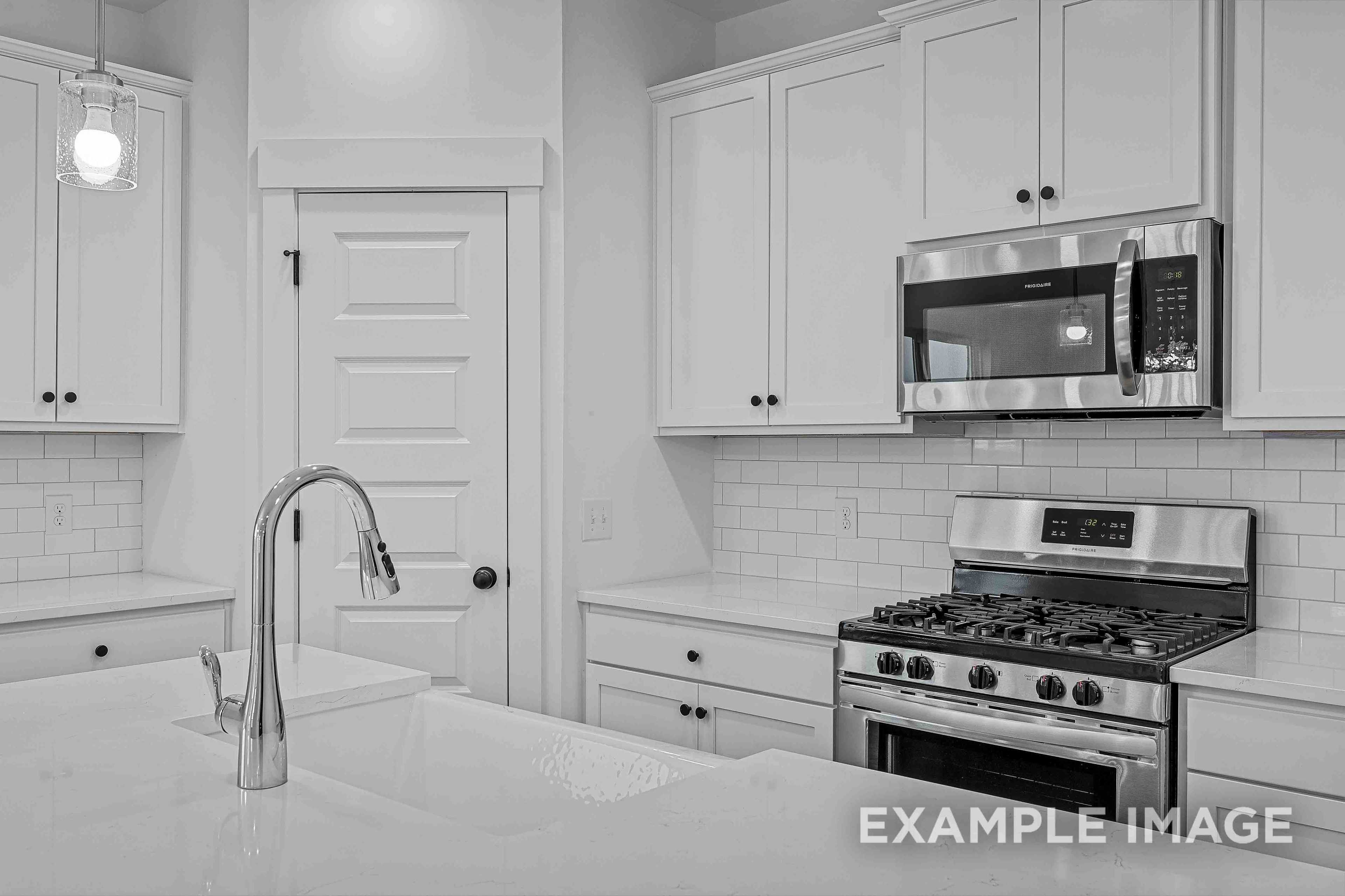 Modern kitchen in The Charleston featuring white shaker cabinets, stainless steel appliances, and subway tile backsplash