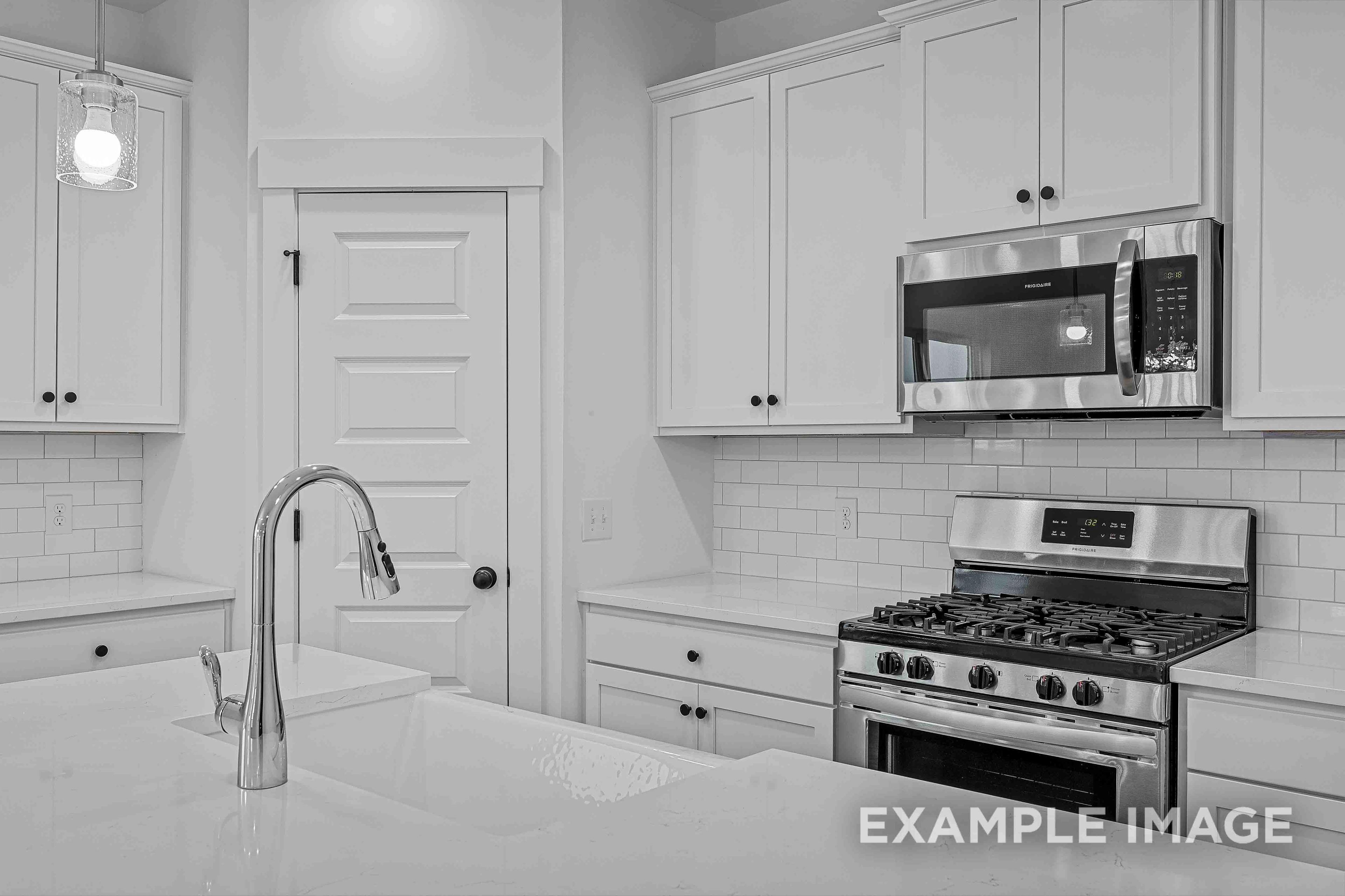 Modern kitchen in The Charleston featuring white shaker cabinets, stainless steel appliances, and subway tile backsplash