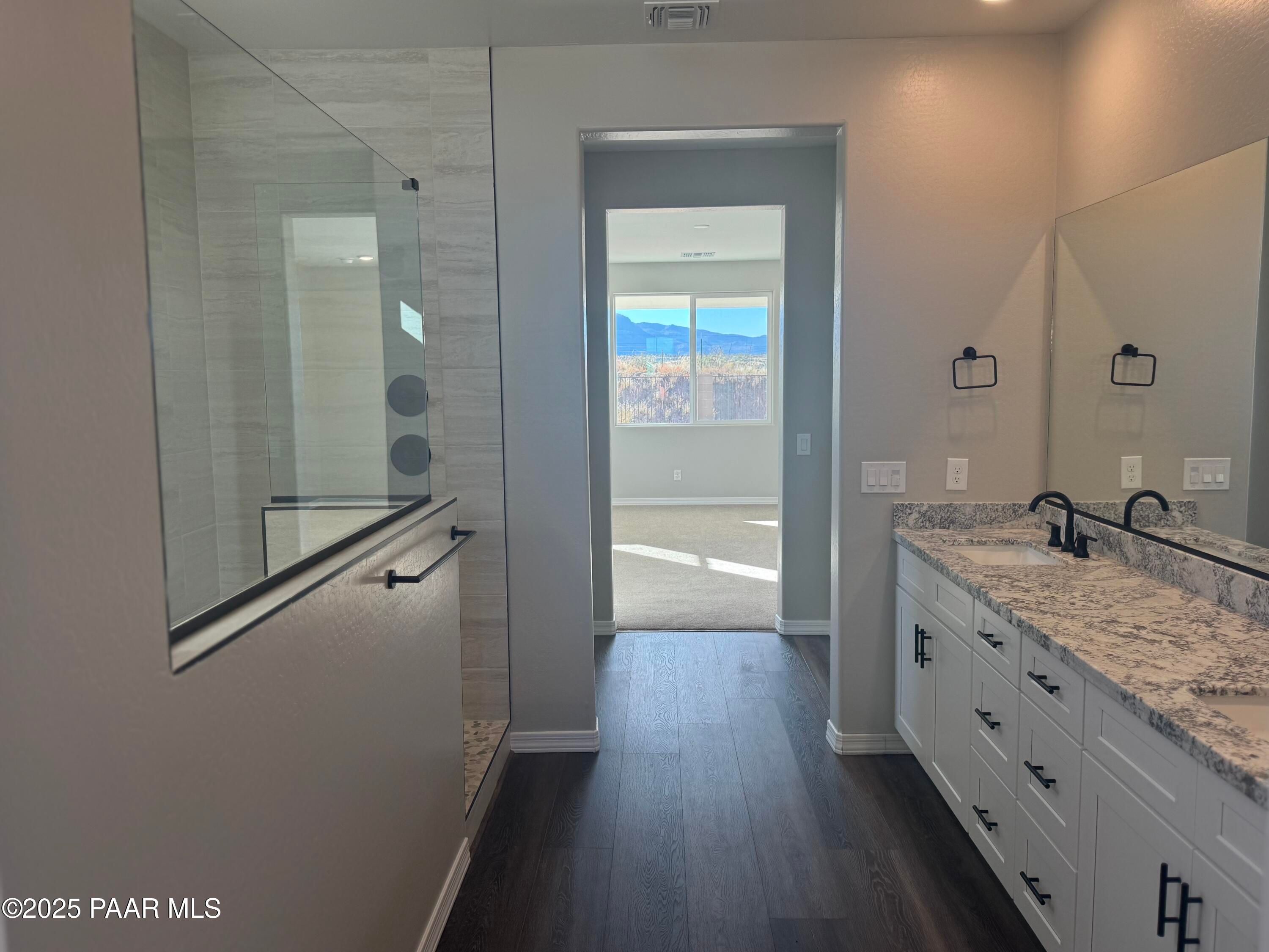 Luxurious master bathroom with frameless glass shower, quartz double vanity, and mountain view in Davidson Homes The Monarch E, Prescott, Arizona