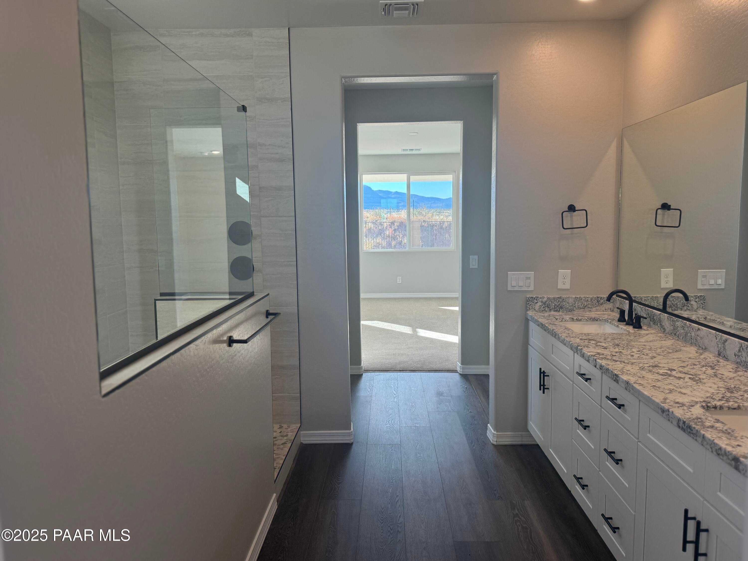 Luxurious master bathroom with frameless glass shower, quartz double vanity, and mountain view in Davidson Homes The Monarch E, Prescott, Arizona