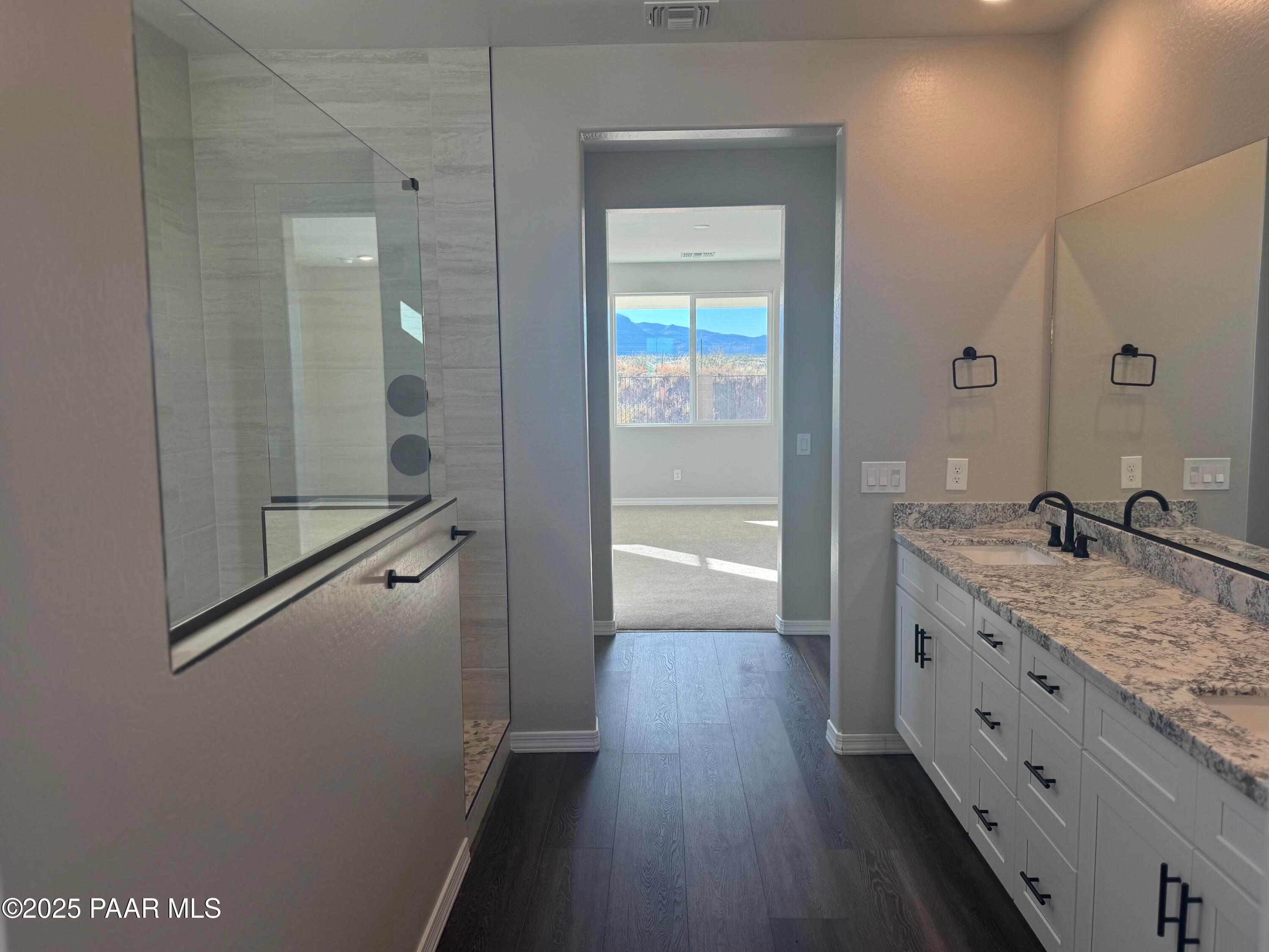 Luxurious master bathroom with frameless glass shower, quartz double vanity, and mountain view in Davidson Homes The Monarch E, Prescott, Arizona