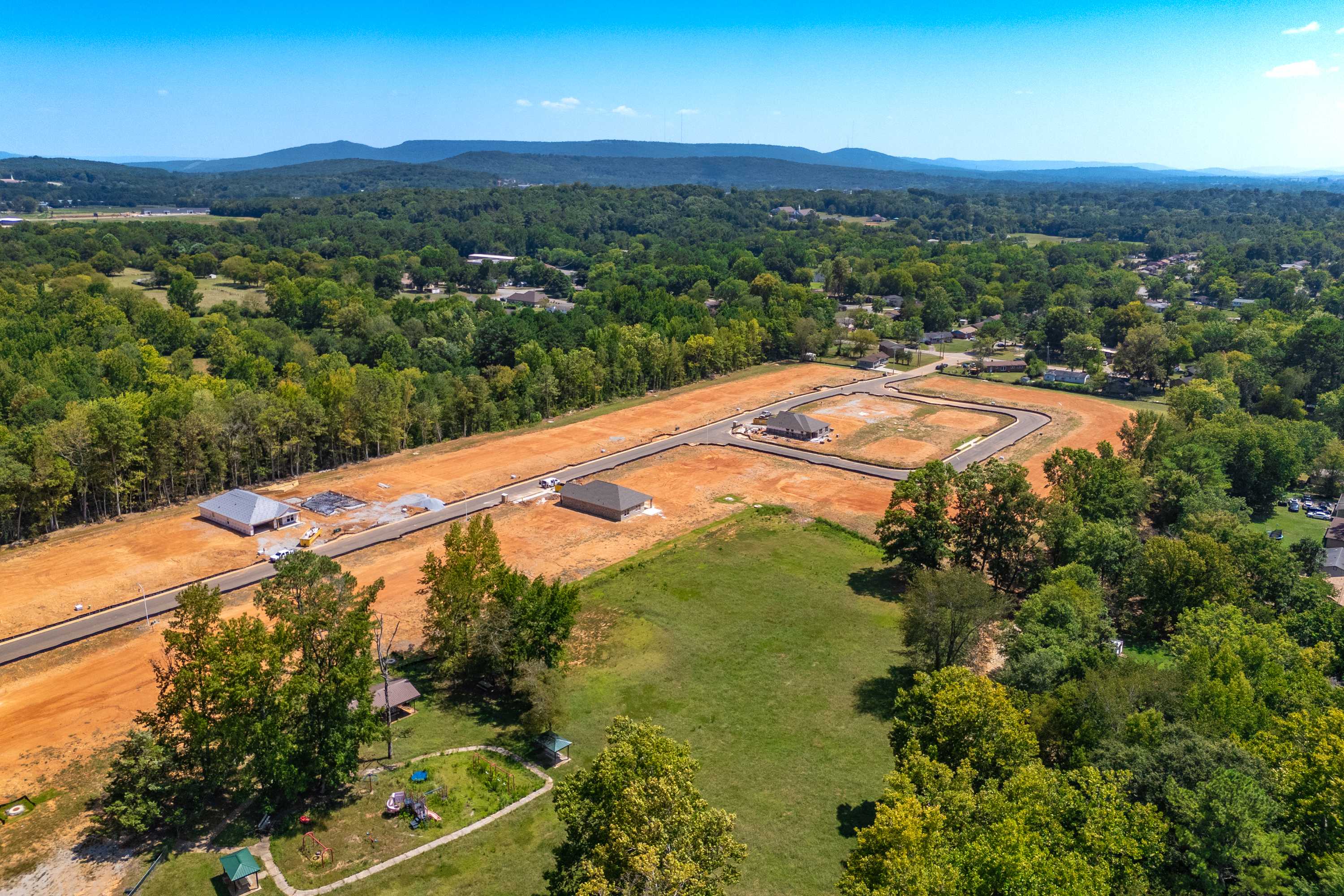 Aerial view of Spragins Cove development in Huntsville Alabama with new home construction sites, dirt roads, and surrounding forests