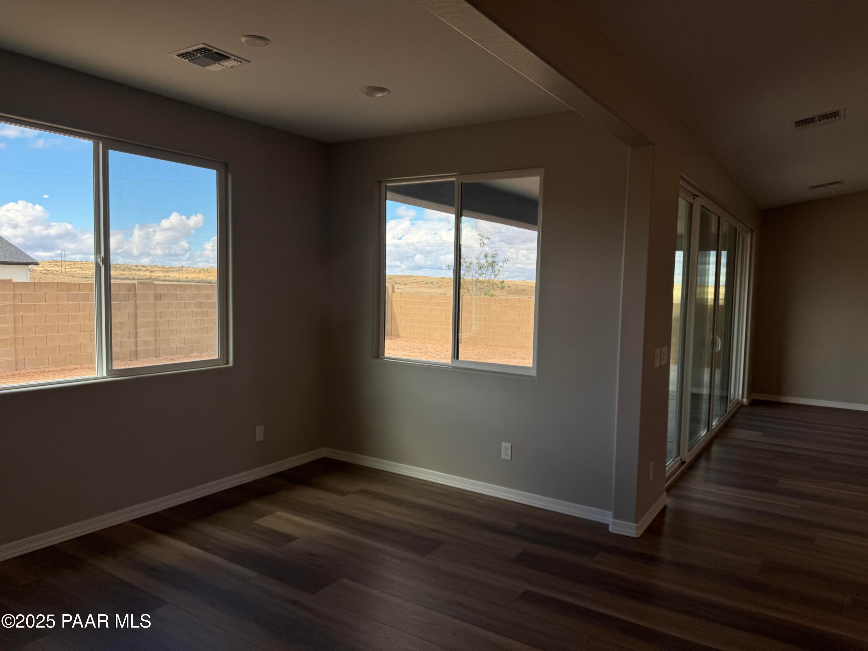 Bright living room with large windows and sliding doors offering desert views in Davidson Homes The Monarch A, Prescott, Arizona