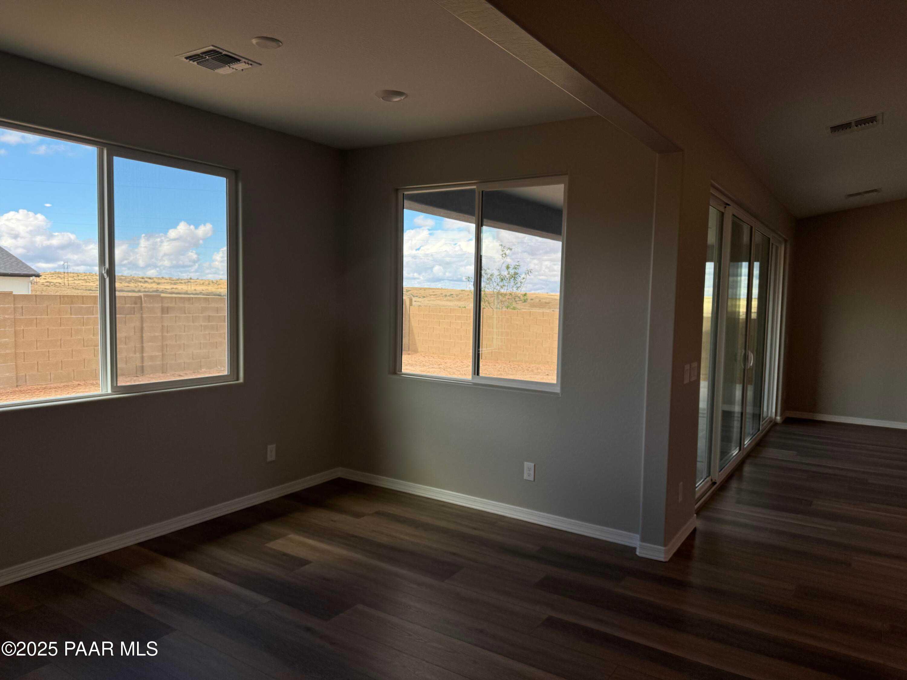 Bright living room with large windows and sliding doors offering desert views in Davidson Homes The Monarch A, Prescott, Arizona