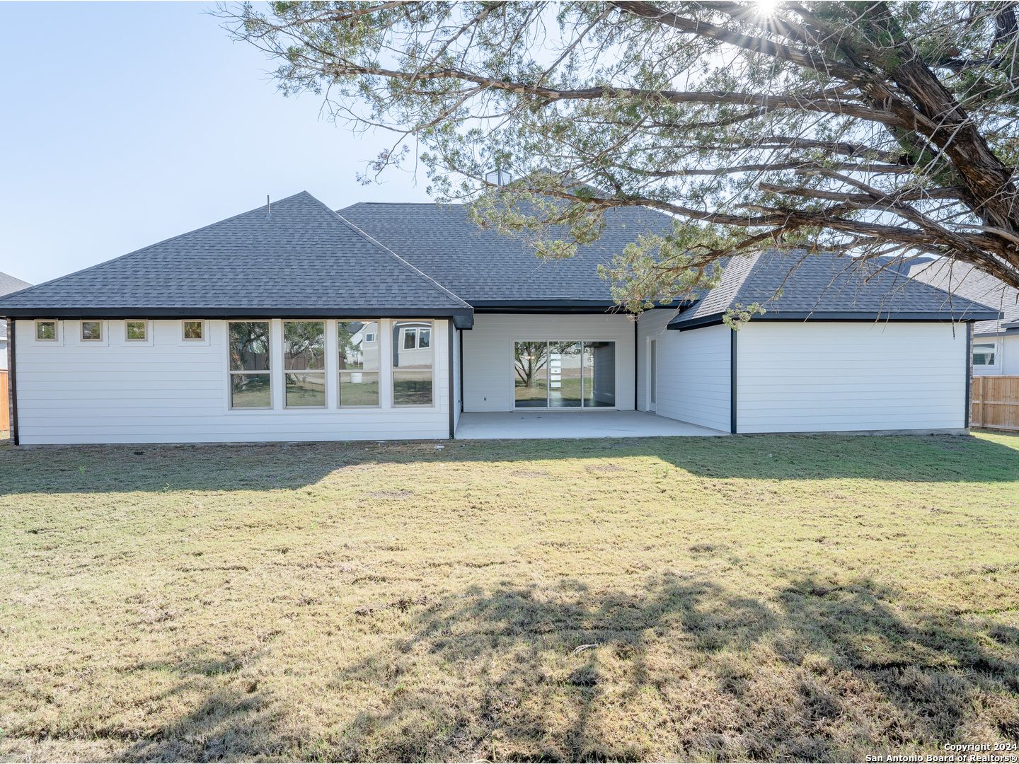 Back view of modern single-story Summerlin A home by Davidson Homes in Potranco Oaks, Castroville, Texas, with covered patio and large windows