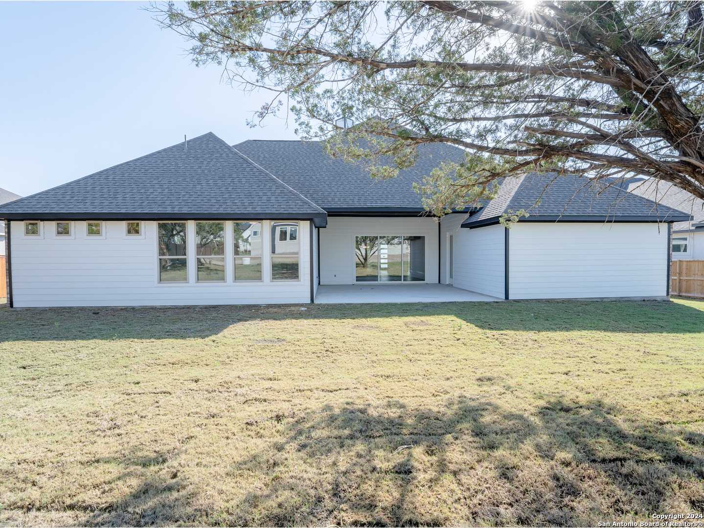 Back view of modern single-story Summerlin A home by Davidson Homes in Potranco Oaks, Castroville, Texas, with covered patio and large windows