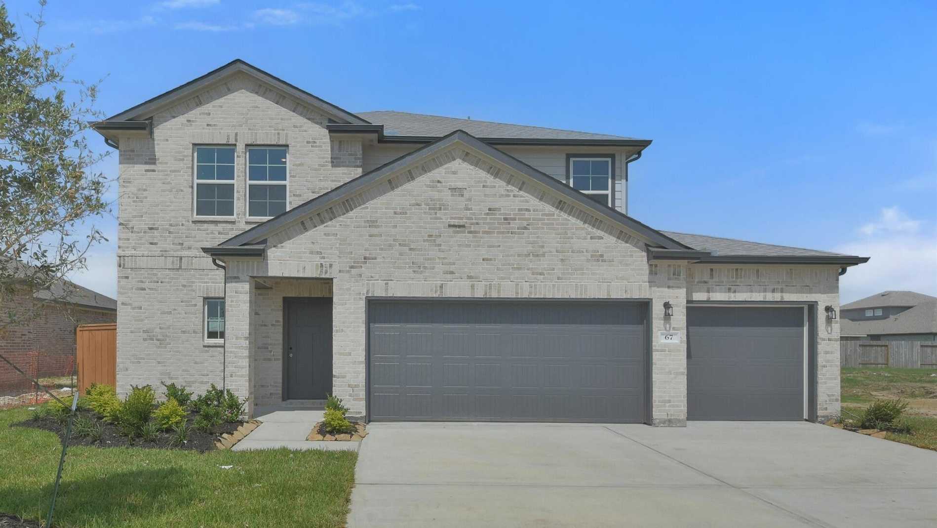 Modern two-story beige brick home at 67 Leon Way, Davidson Homes open house with double garage, porch, and lush green yard