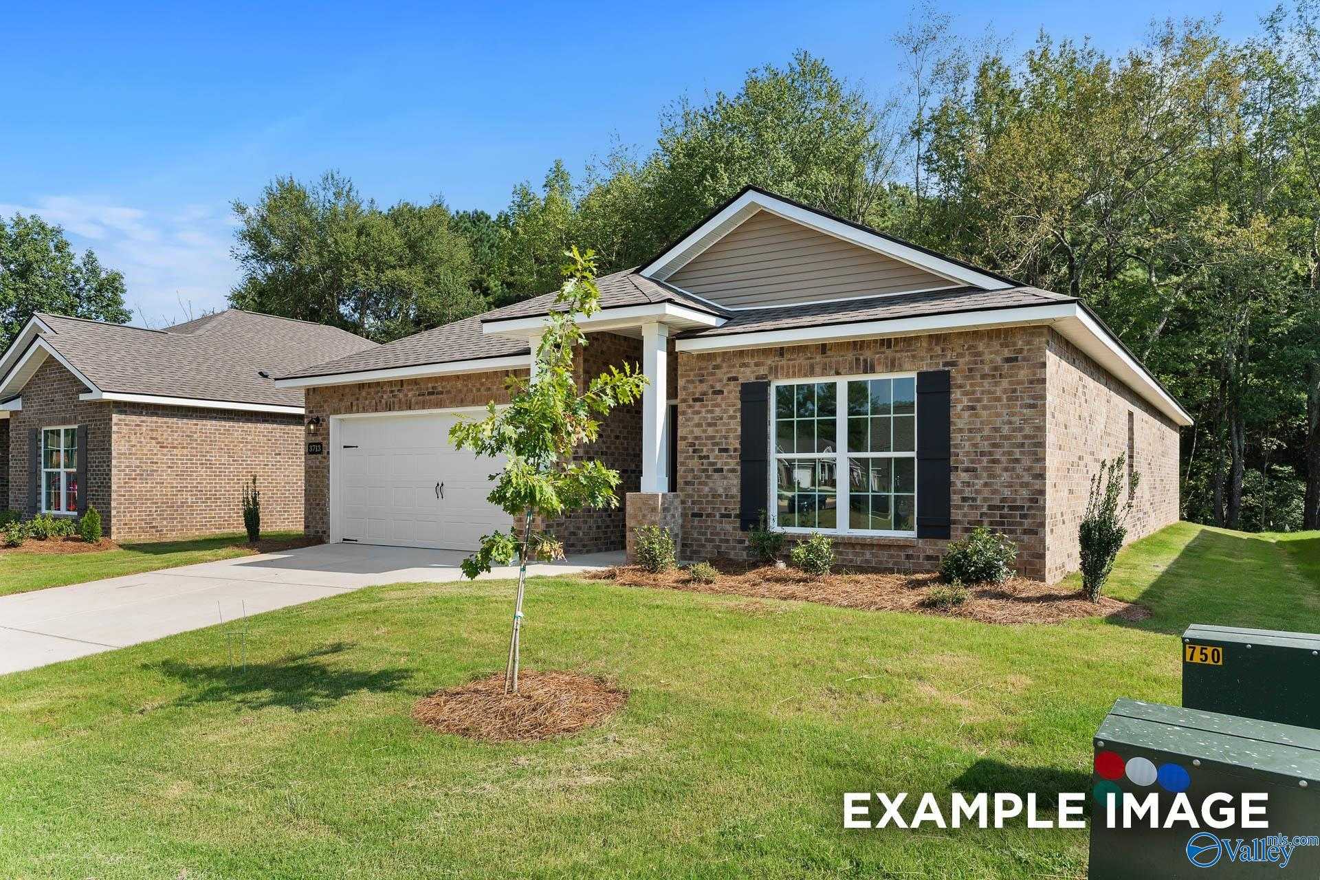 Brick single-story home with 2-car garage, driveway, and landscaped front yard in Heritage Lakes, New Market, Alabama
