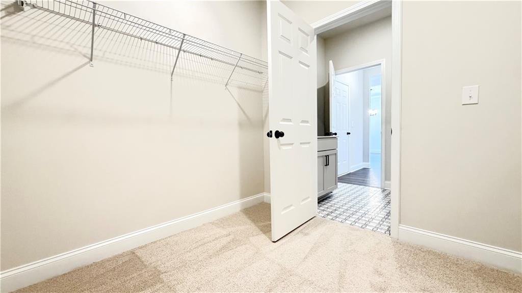 Walk-in closet with wire shelving in The Ash C floor plan at Wehunt Meadows, Hoschton, Georgia by Davidson Homes.
