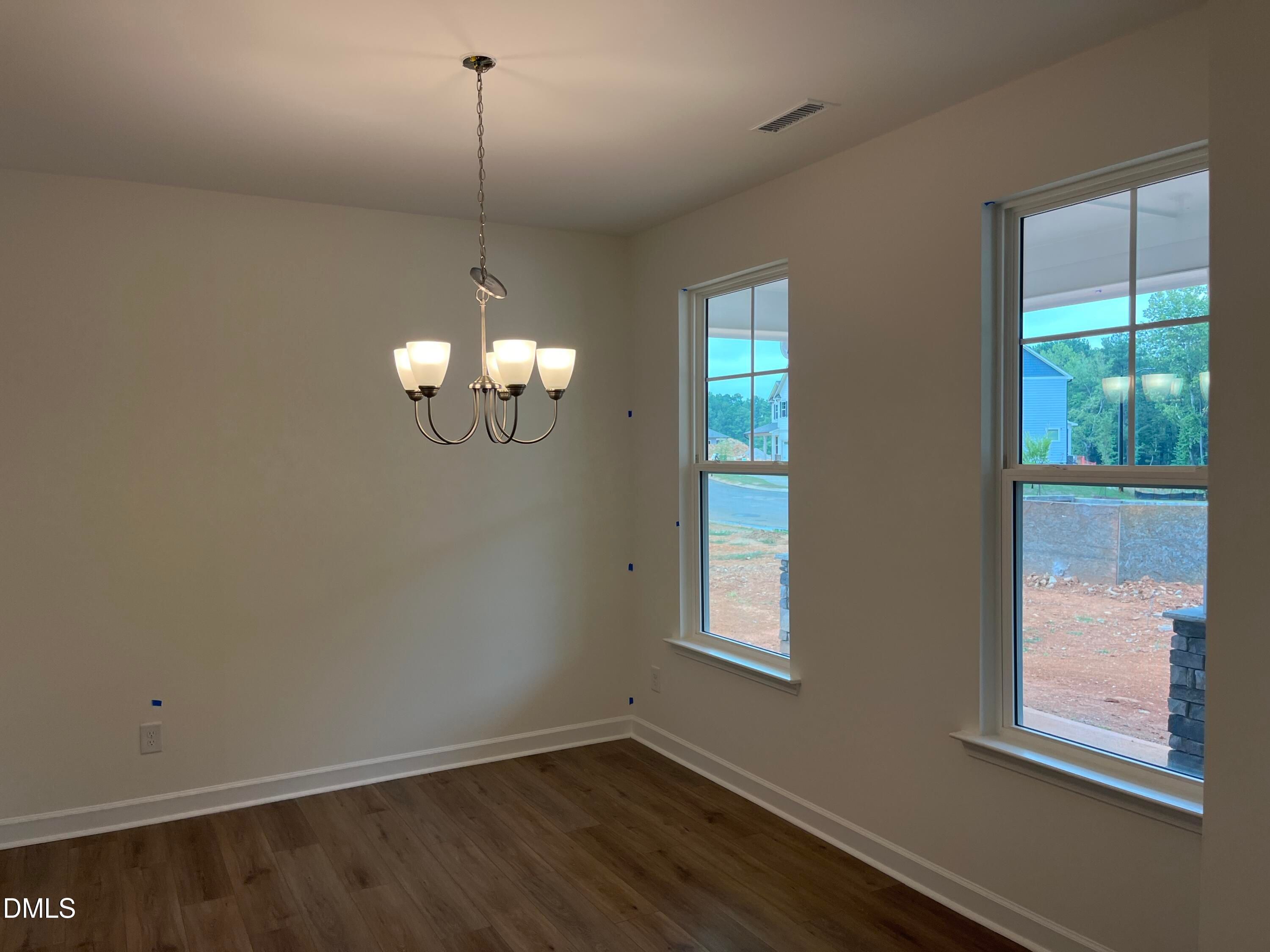 Bright dining room with chandelier, hardwood floors, and large windows in Davidson Homes The Willow G, Wake Forest, NC