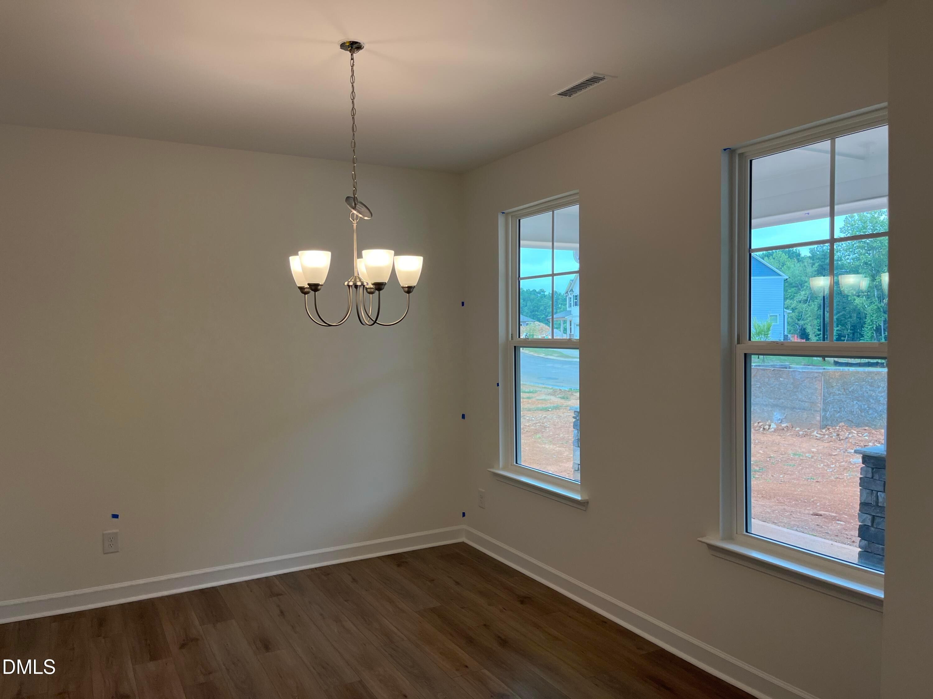 Bright dining room with chandelier, hardwood floors, and large windows in Davidson Homes The Willow G, Wake Forest, NC