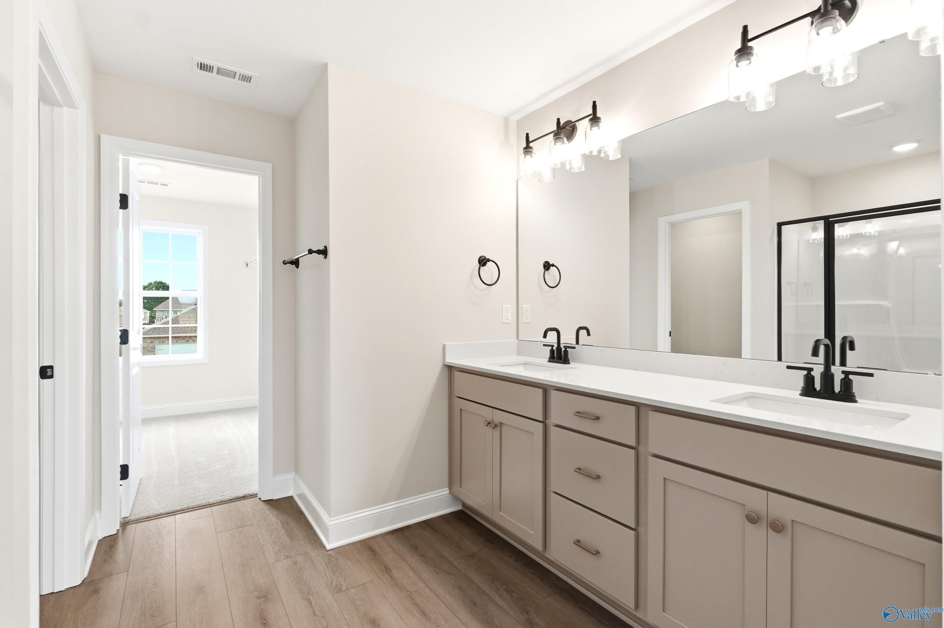 Modern double vanity with white countertops and matte black fixtures in The Shelby A home, Clearview, Hazel Green, Alabama.
