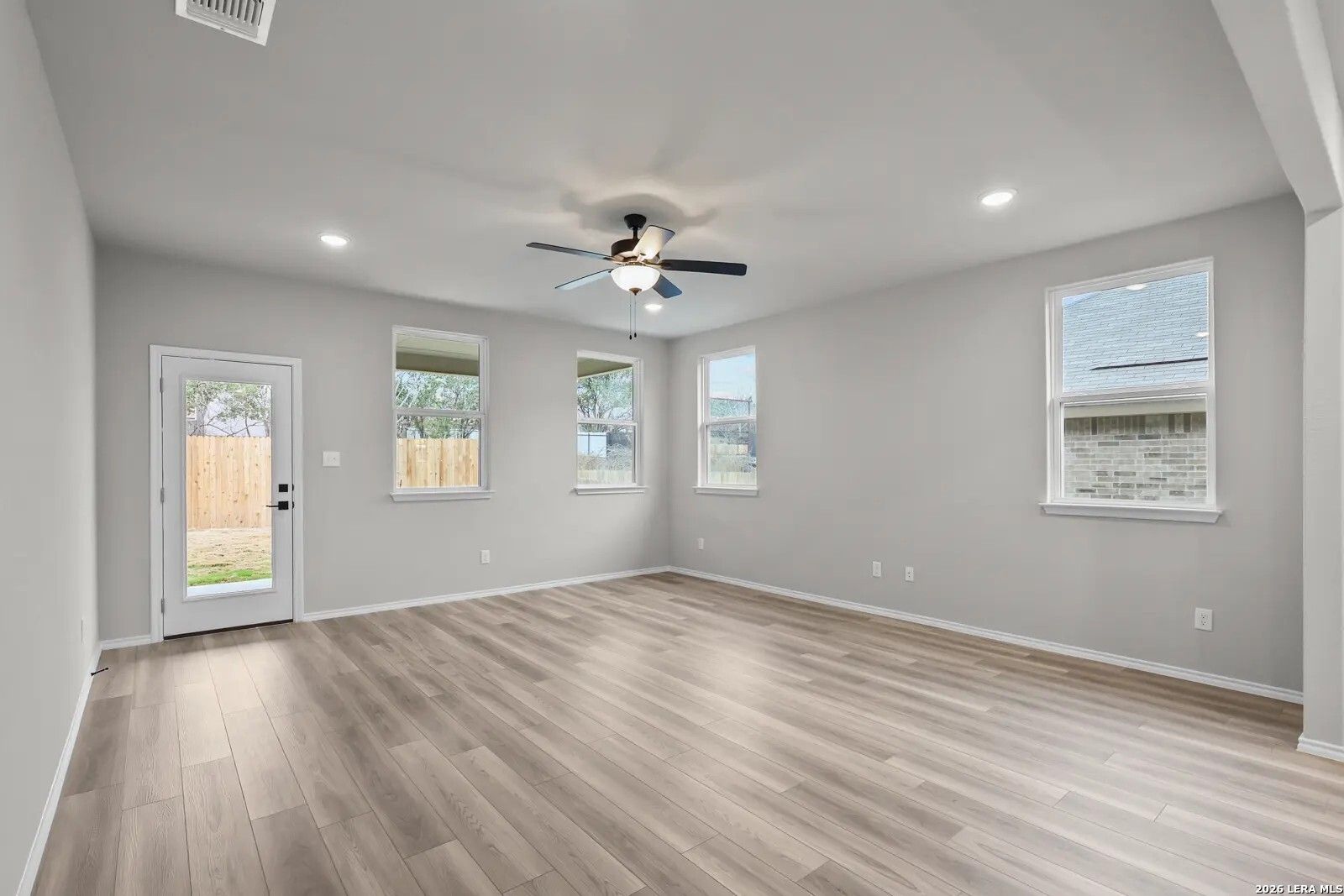 Spacious, light-filled living area with wood-look flooring in The Glenwood E floor plan, Comanche Ridge, San Antonio.