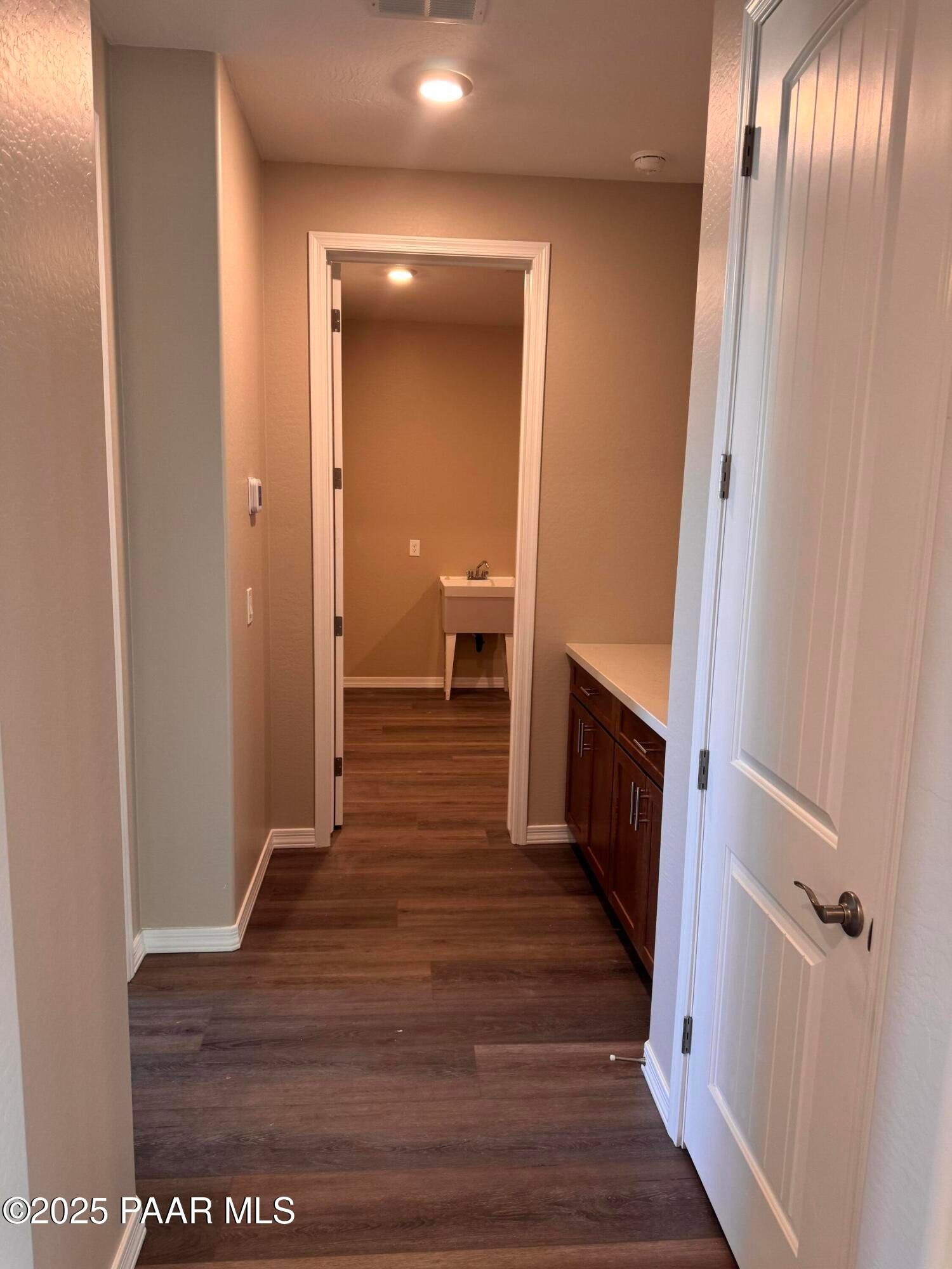 Bright hallway with wood floors leading to bathroom vanity and sink in Davidson Homes The Sunrise II A, Prescott Arizona