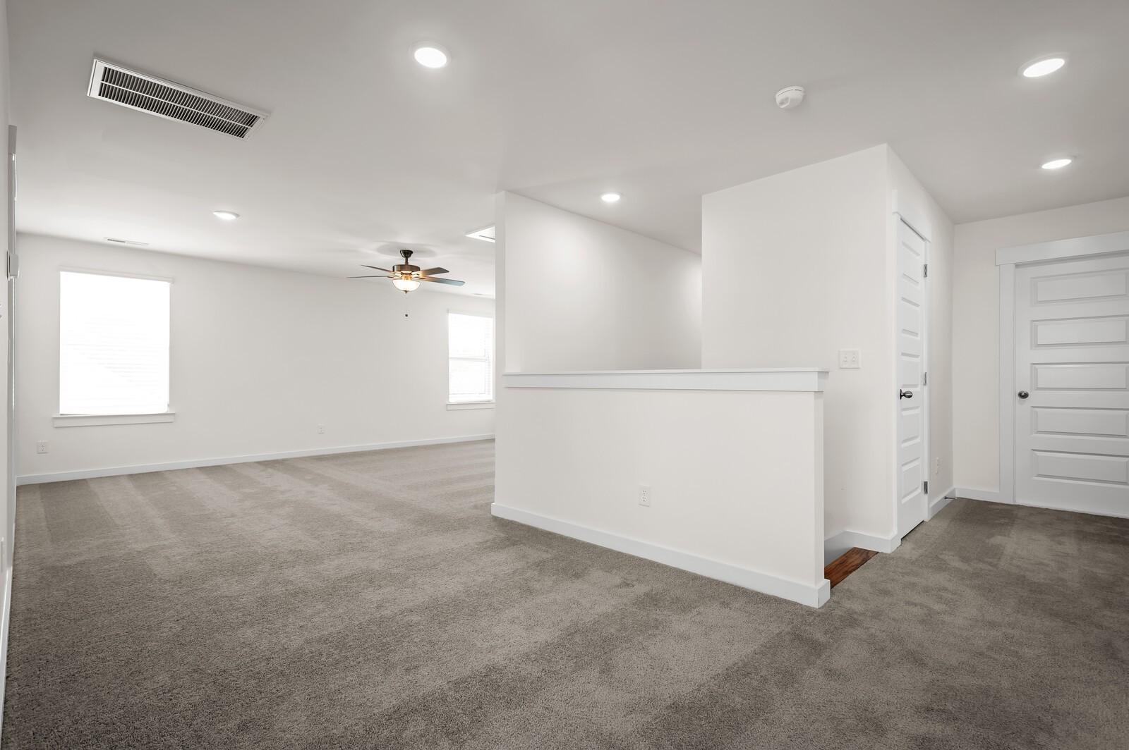 Spacious carpeted loft area in The Ash A floor plan at Woods Crossing in Gallatin, Tennessee by Davidson Homes.