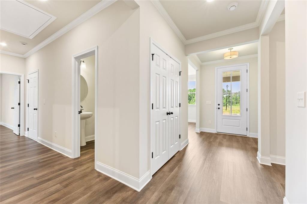 Bright entry hallway with powder room, coat closet, and hardwood floors in Davidson Homes The Harrison G, Hoschton, GA