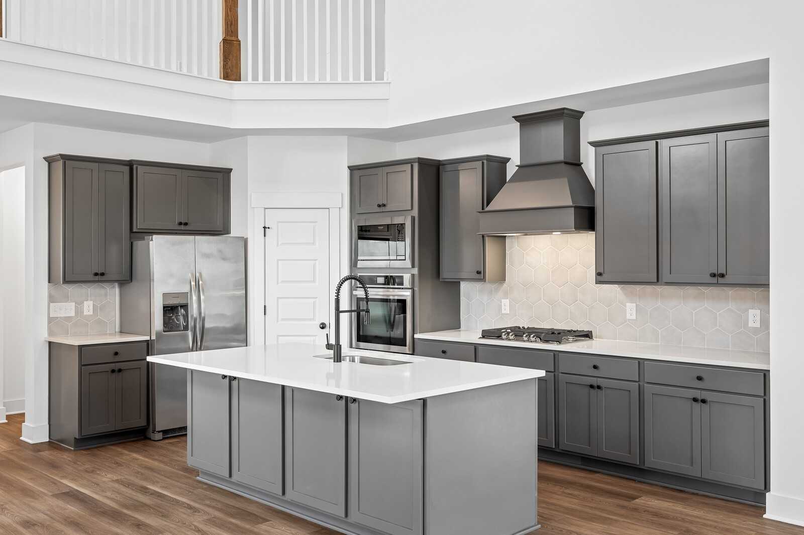 Modern gray shaker kitchen with white quartz island, stainless appliances, and open loft in Davidson Homes Ridgeport, Gallatin TN