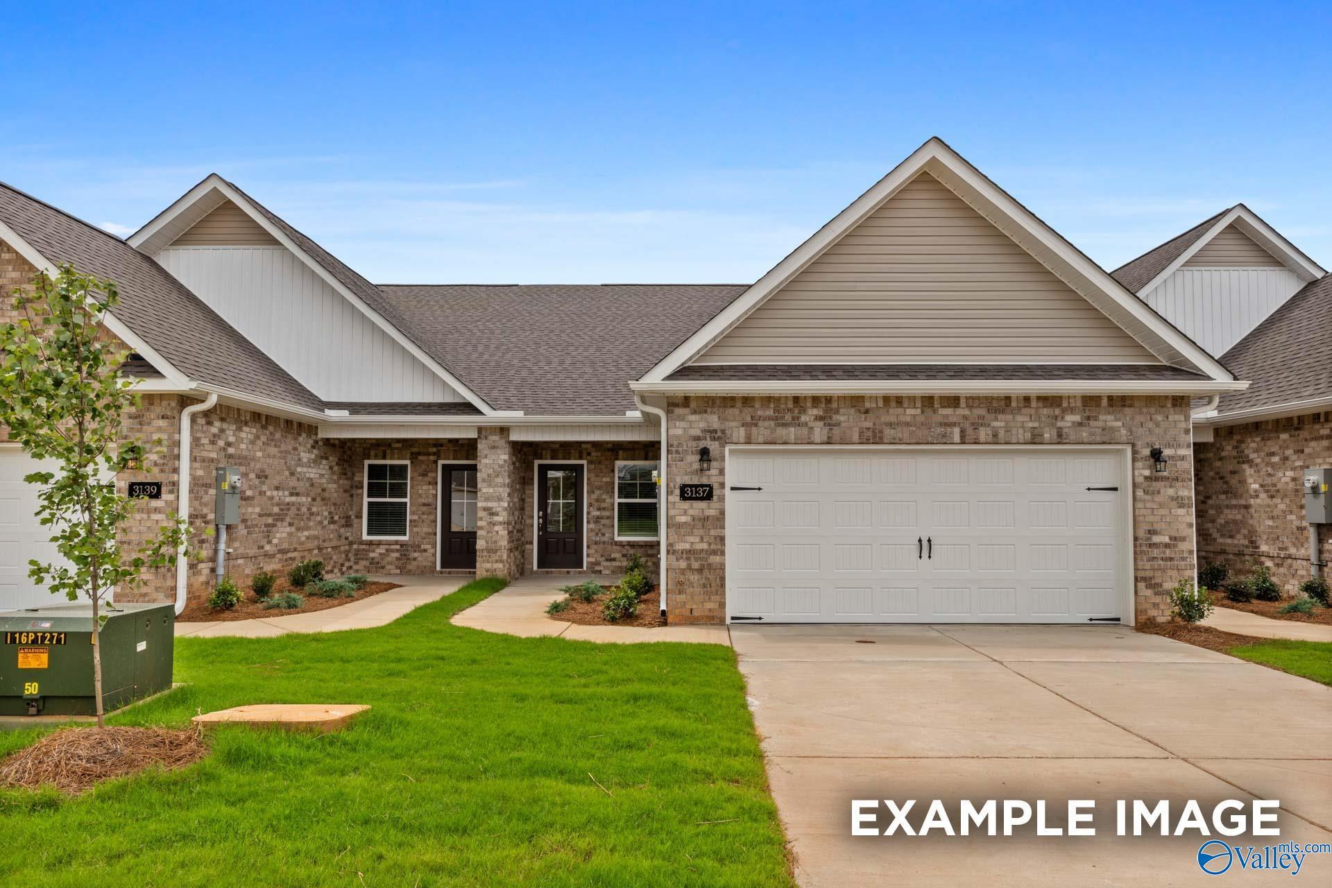 Modern single-story Cumberland C home with beige siding, brick facade, 2-car garage, and landscaped lawn in Decatur, Alabama