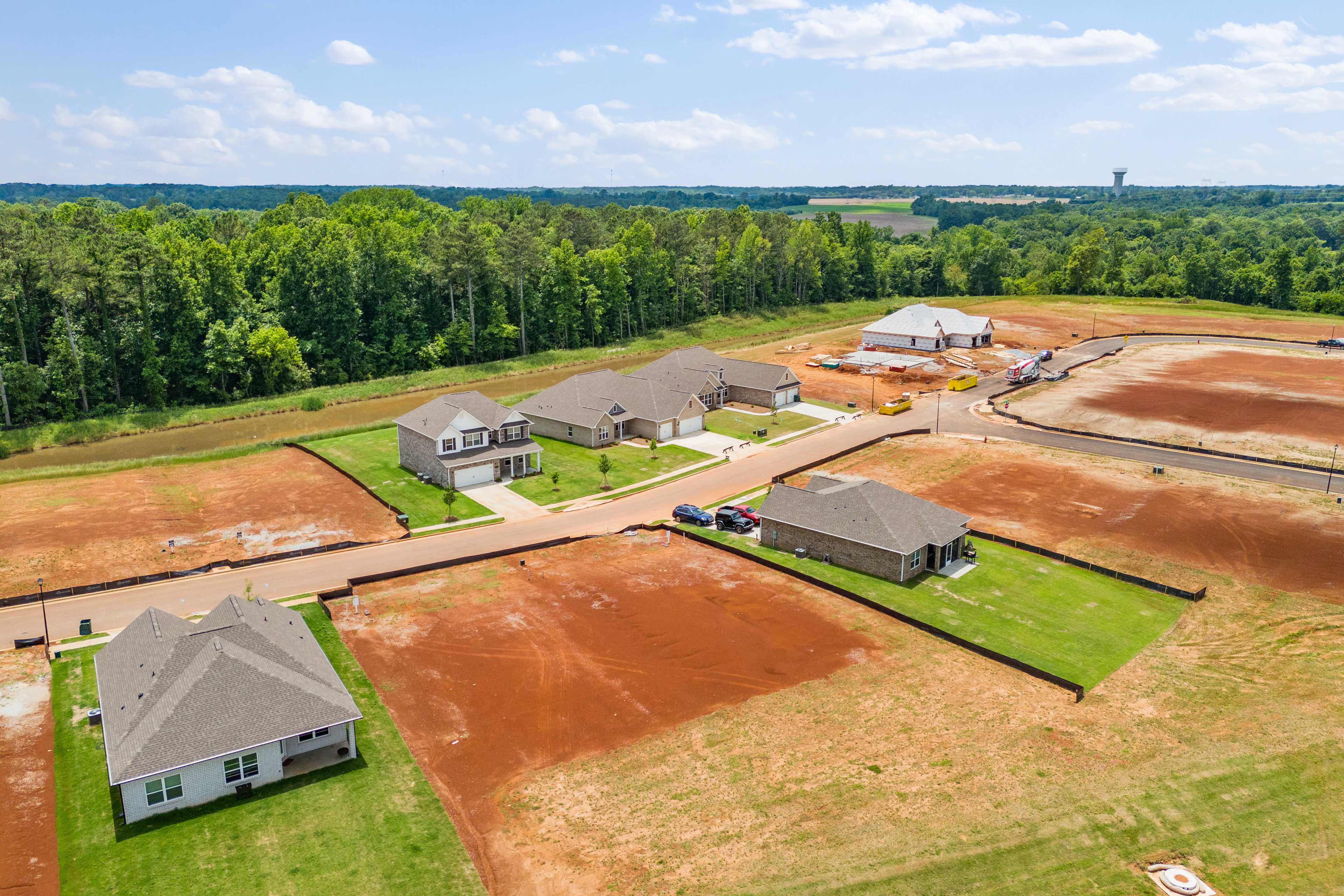 Aerial view of new Davidson Homes under construction at Creekside in Harvest Alabama surrounded by pine forests