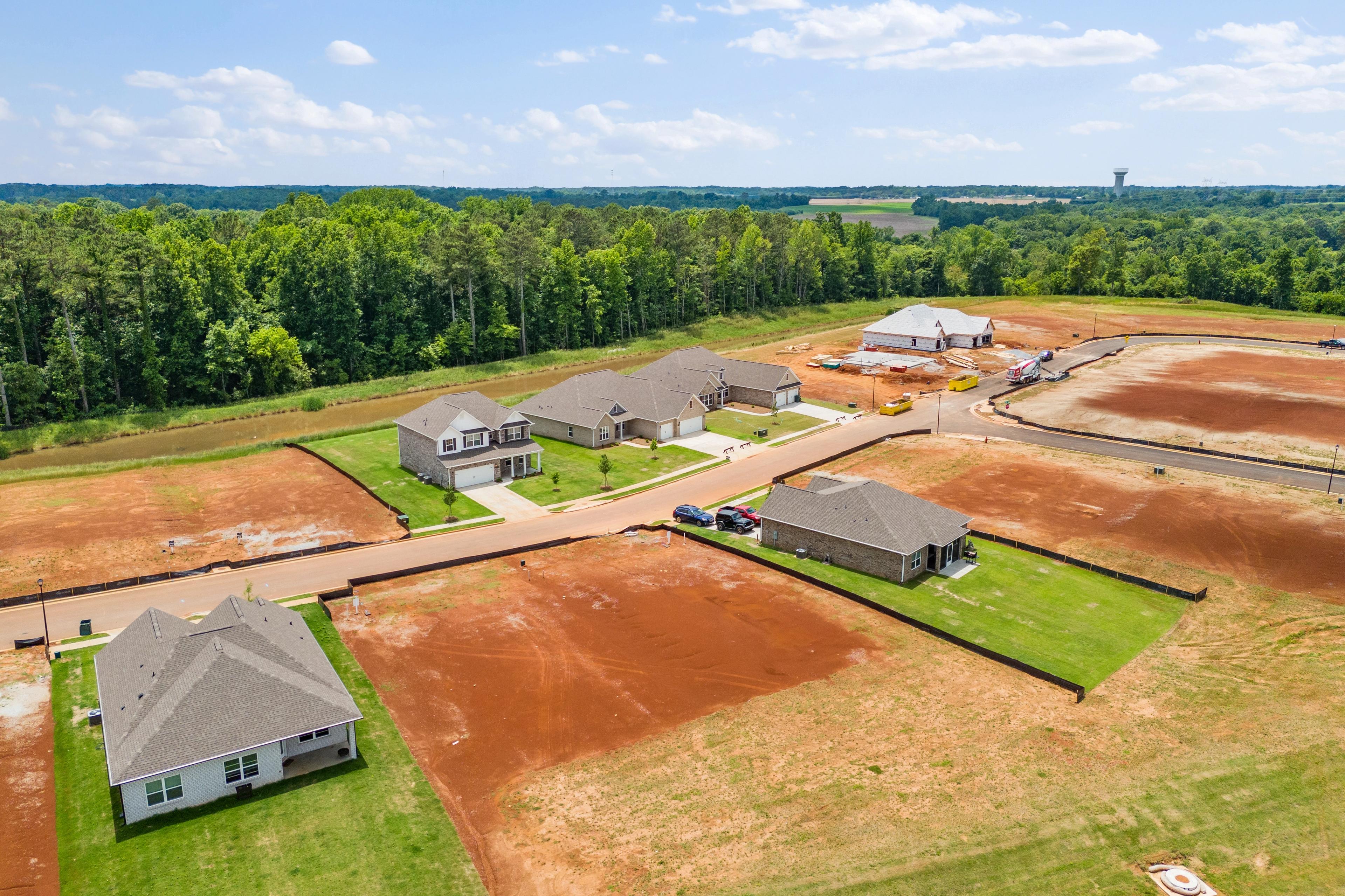 Aerial view of new Davidson Homes under construction at Creekside in Harvest Alabama surrounded by pine forests