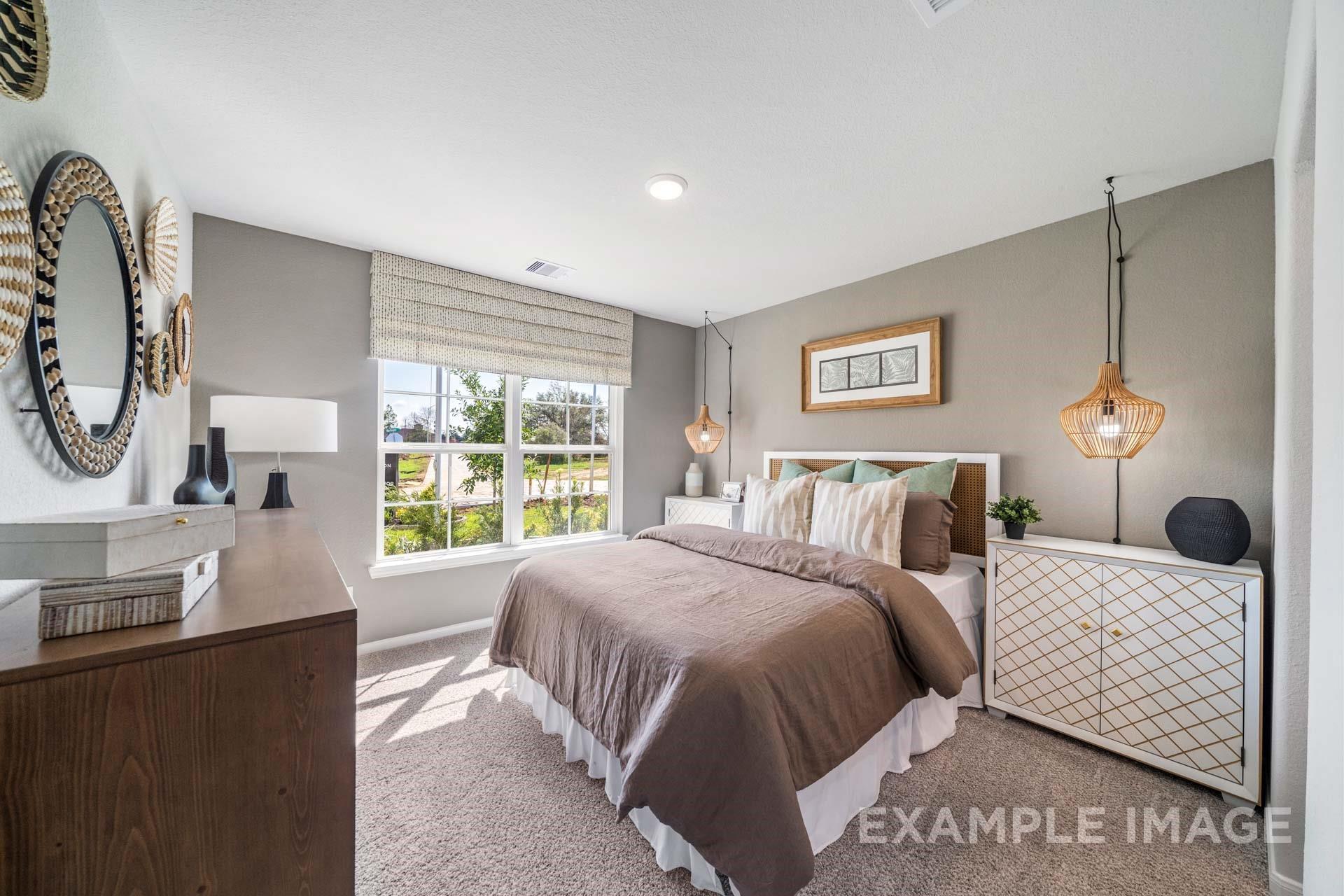 Bright bedroom with rattan pendant light, cane headboard, and sunny window in Davidson Homes The Acadia A in Lago Mar, Texas City