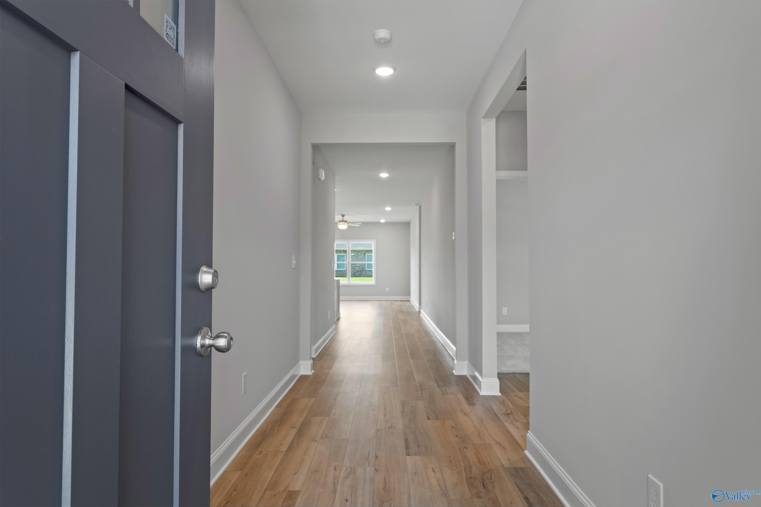Bright entry hallway with hardwood floors, recessed lights, and natural window in Davidson Homes The Daphne C, Athens, Alabama