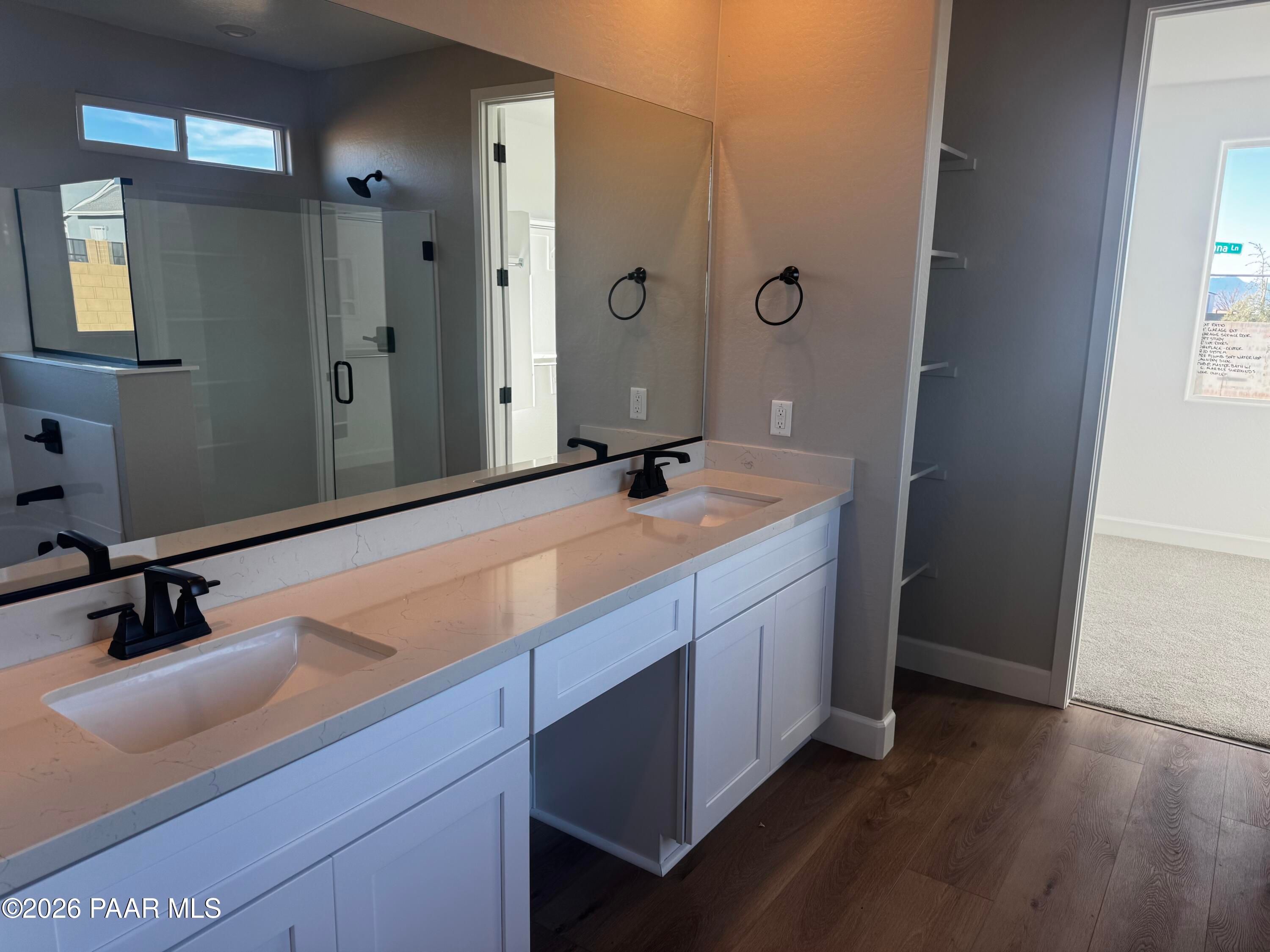 Modern master bathroom featuring double vanity sinks, frameless glass shower, and large mirrors in Evermore Homes The Monarch B, Prescott Valley, AZ