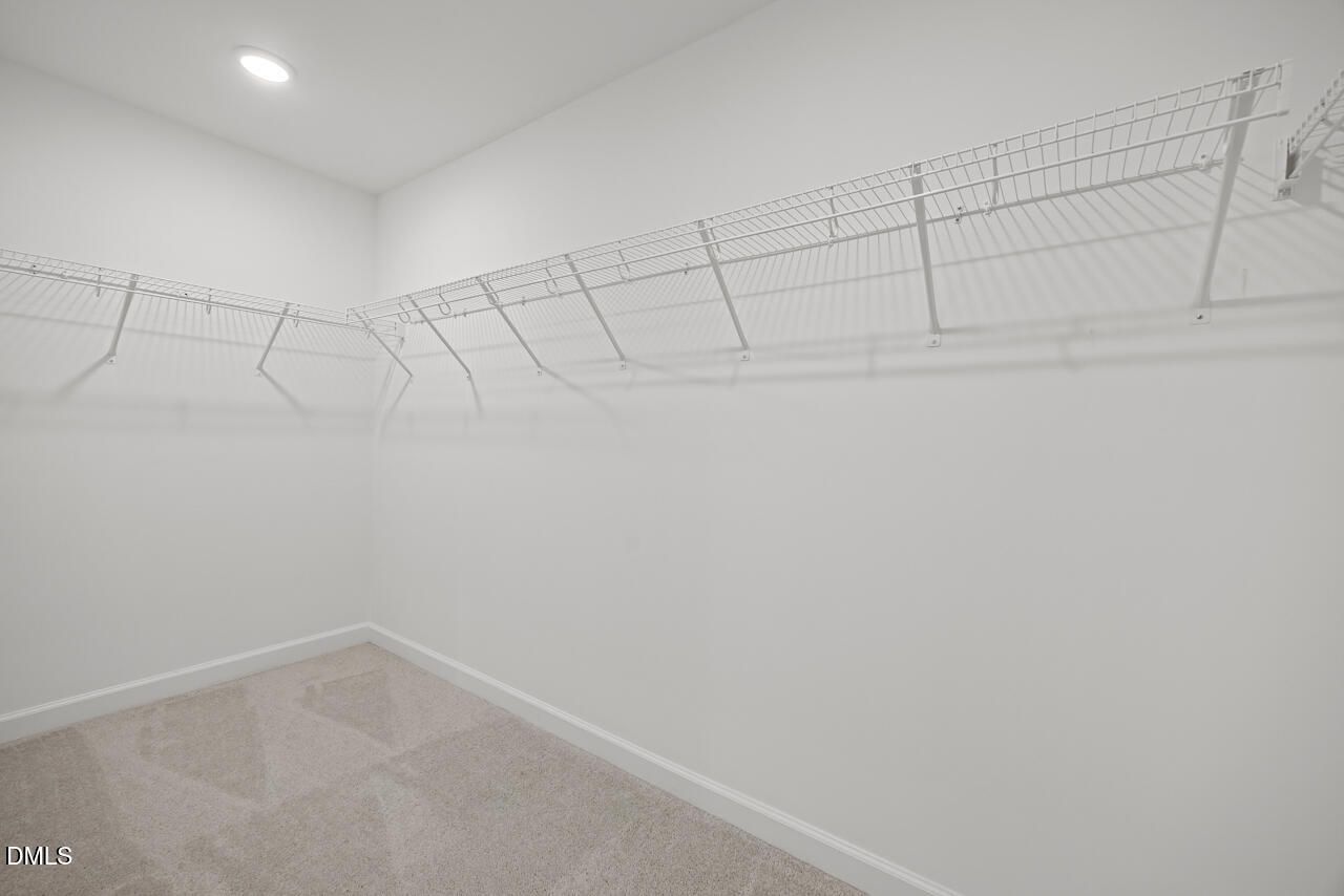 Spacious walk-in closet with white wire shelving in The Gavin A floor plan at Gregory Village in Lillington, North Carolina.