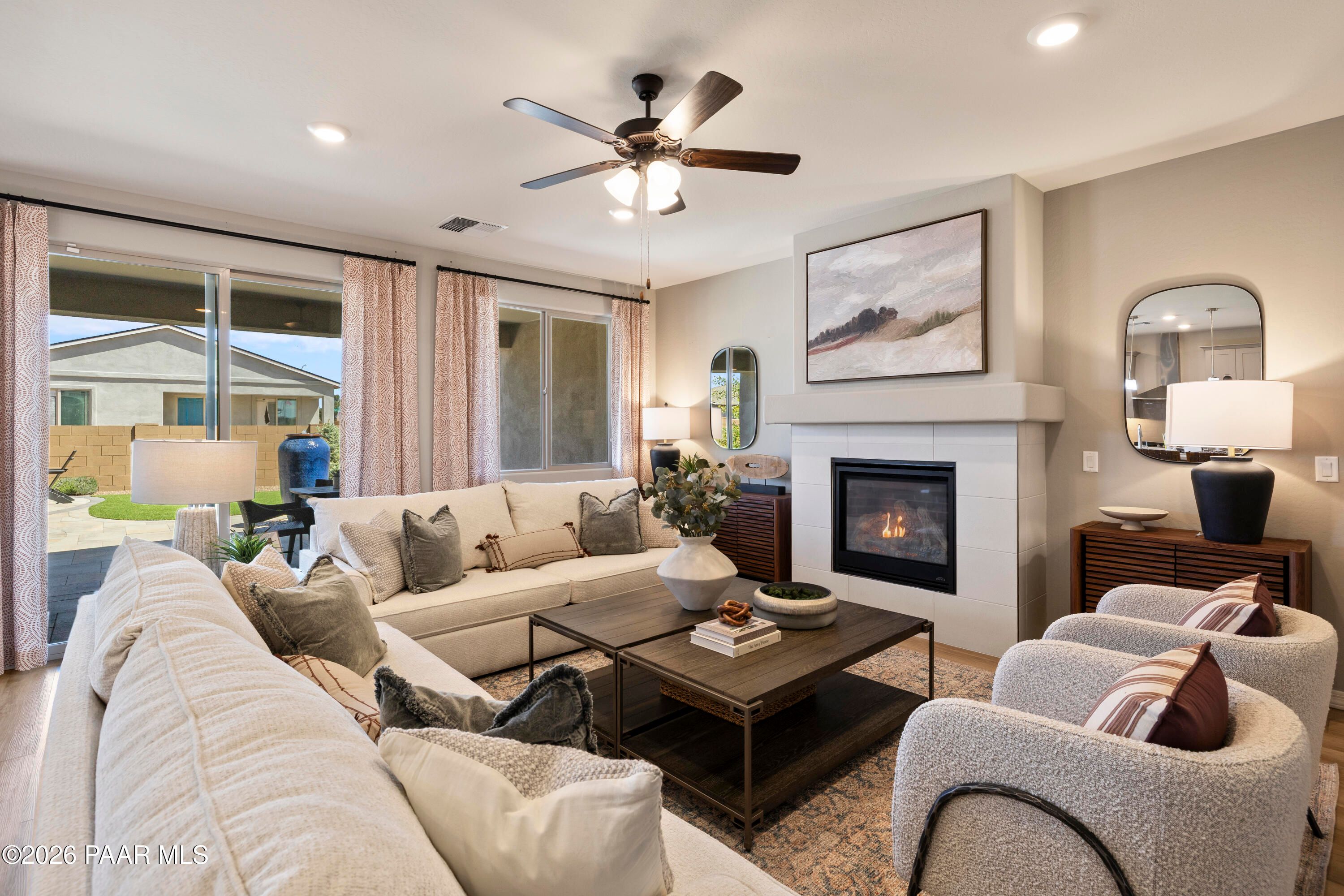 Cozy living room with fireplace and patio access in The Harmony A floor plan at North Ridge, Pronghorn Ranch, Prescott Valley