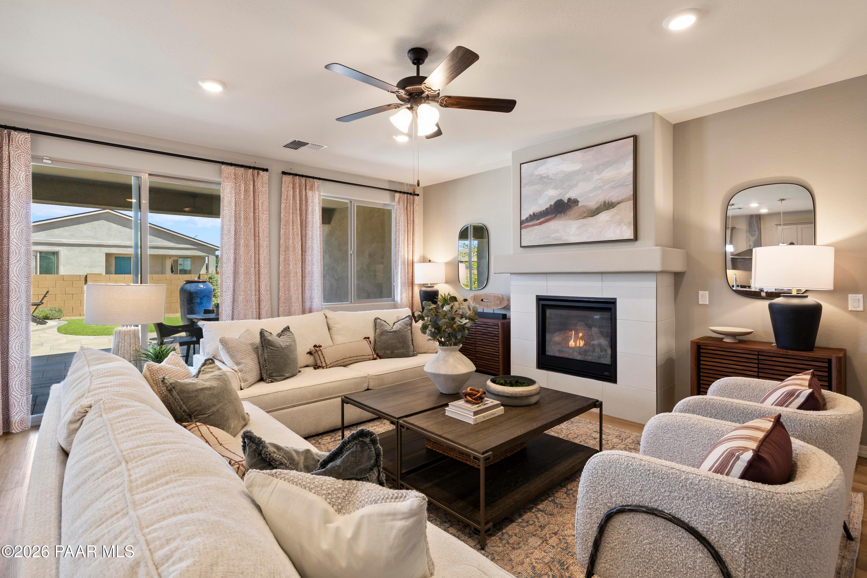 Cozy living room with fireplace and patio access in The Harmony A floor plan at North Ridge, Pronghorn Ranch, Prescott Valley