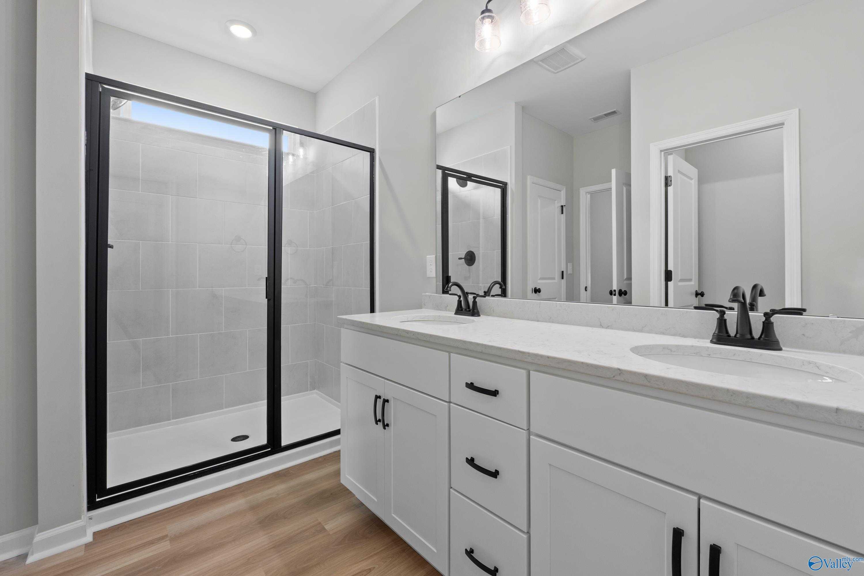 Modern master bathroom with double vanity, frameless glass shower in Evermore Homes The Nantucket, Madison, Alabama