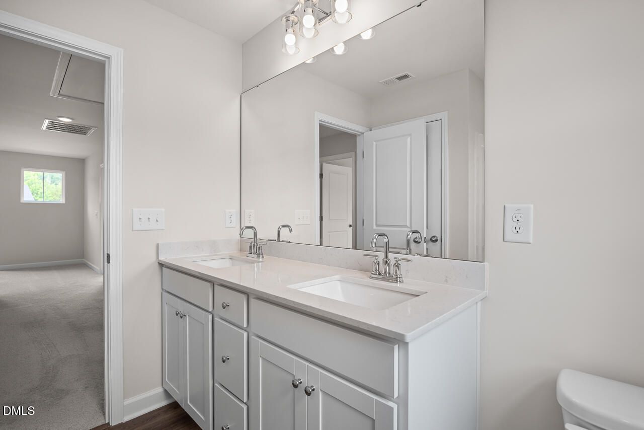 Modern dual-vanity bathroom with quartz countertops in The Willow B floor plan at Woodland Crossing, Zebulon, NC.