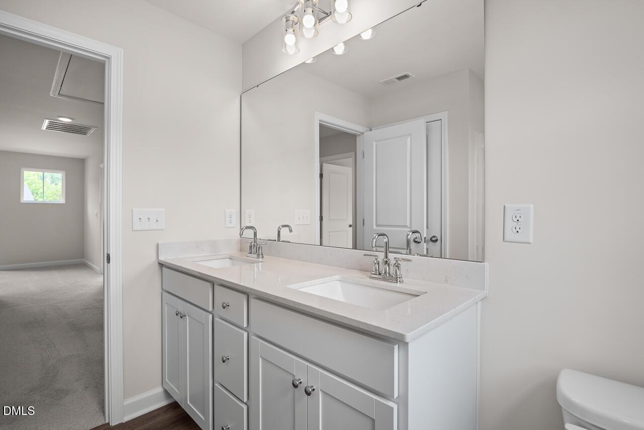 Modern dual-vanity bathroom with quartz countertops in The Willow B floor plan at Woodland Crossing, Zebulon, NC.