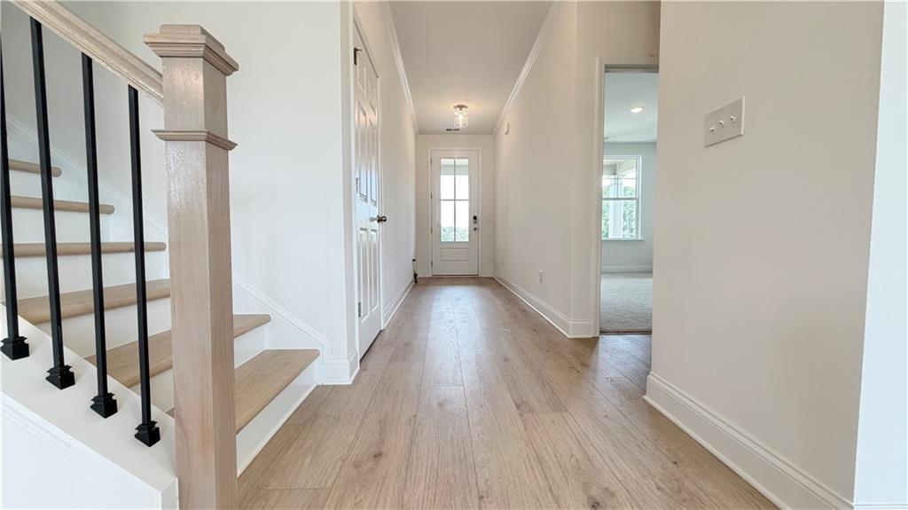Bright foyer with hardwood floors, staircase, and natural light in The Hickory C floor plan, Wehunt Meadows, Hoschton, GA.