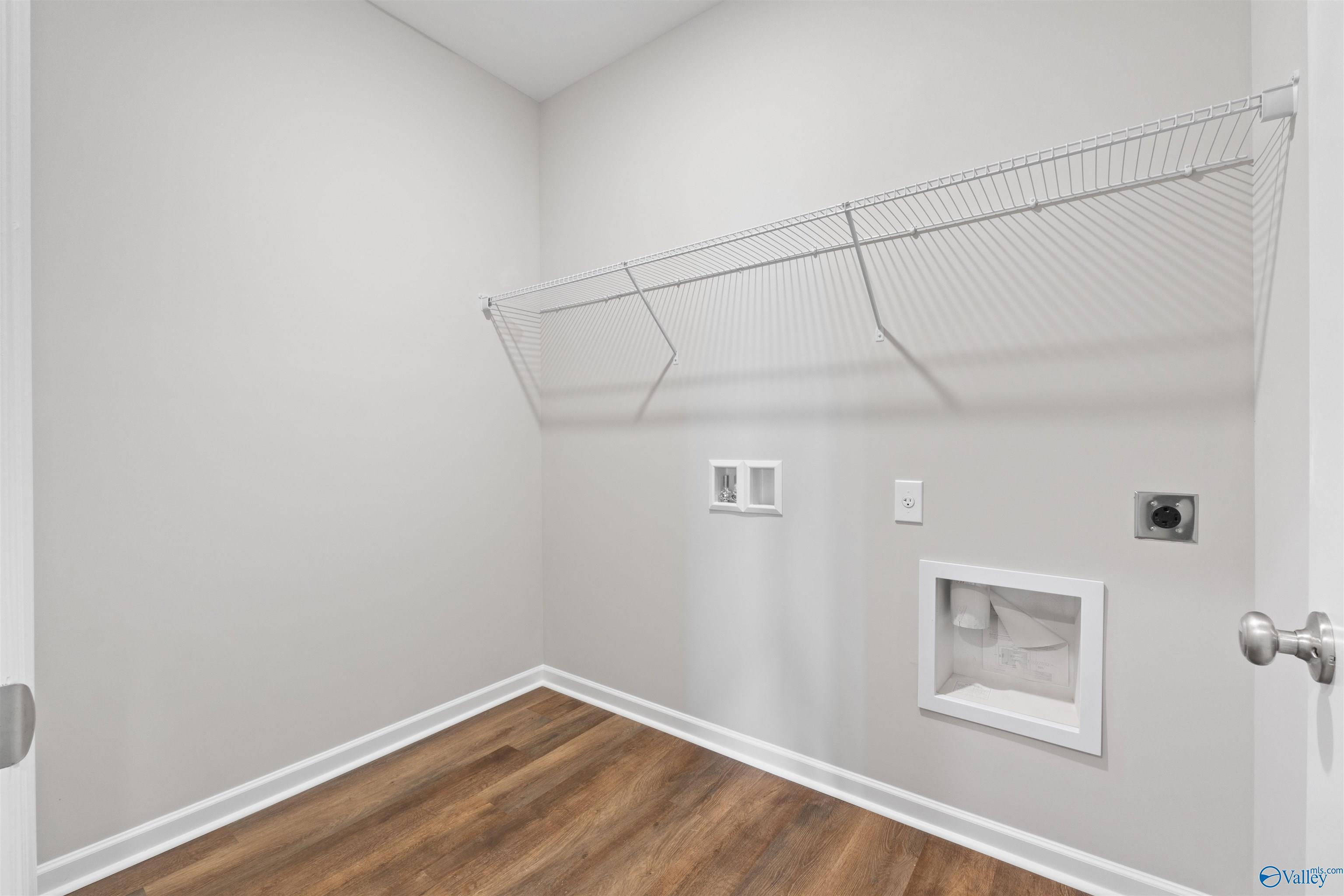 Spacious laundry room with wire shelving, washer-dryer hookups and hardwood floors in Davidson Homes The Luna, Hazel Green, AL