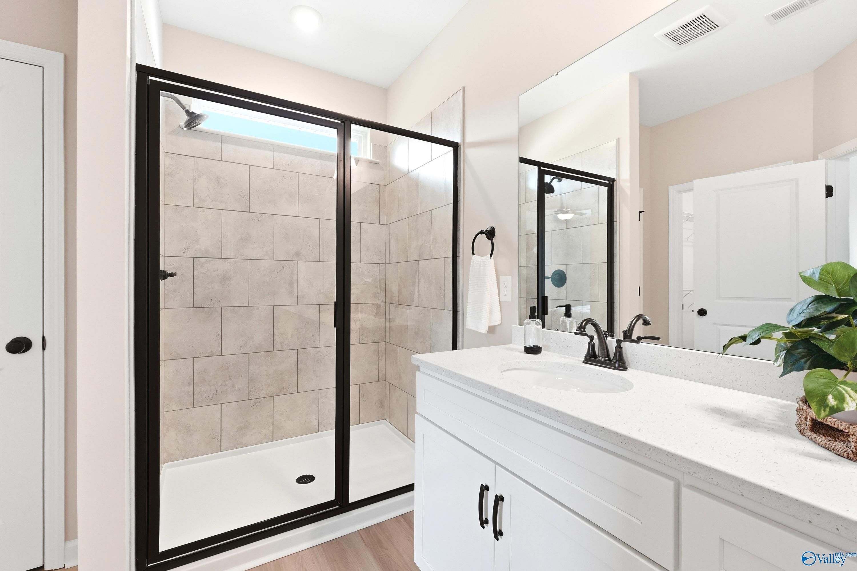 Modern bathroom with tiled walk-in shower and white vanity in The Dorado floor plan at Riverton Preserve, Huntsville.