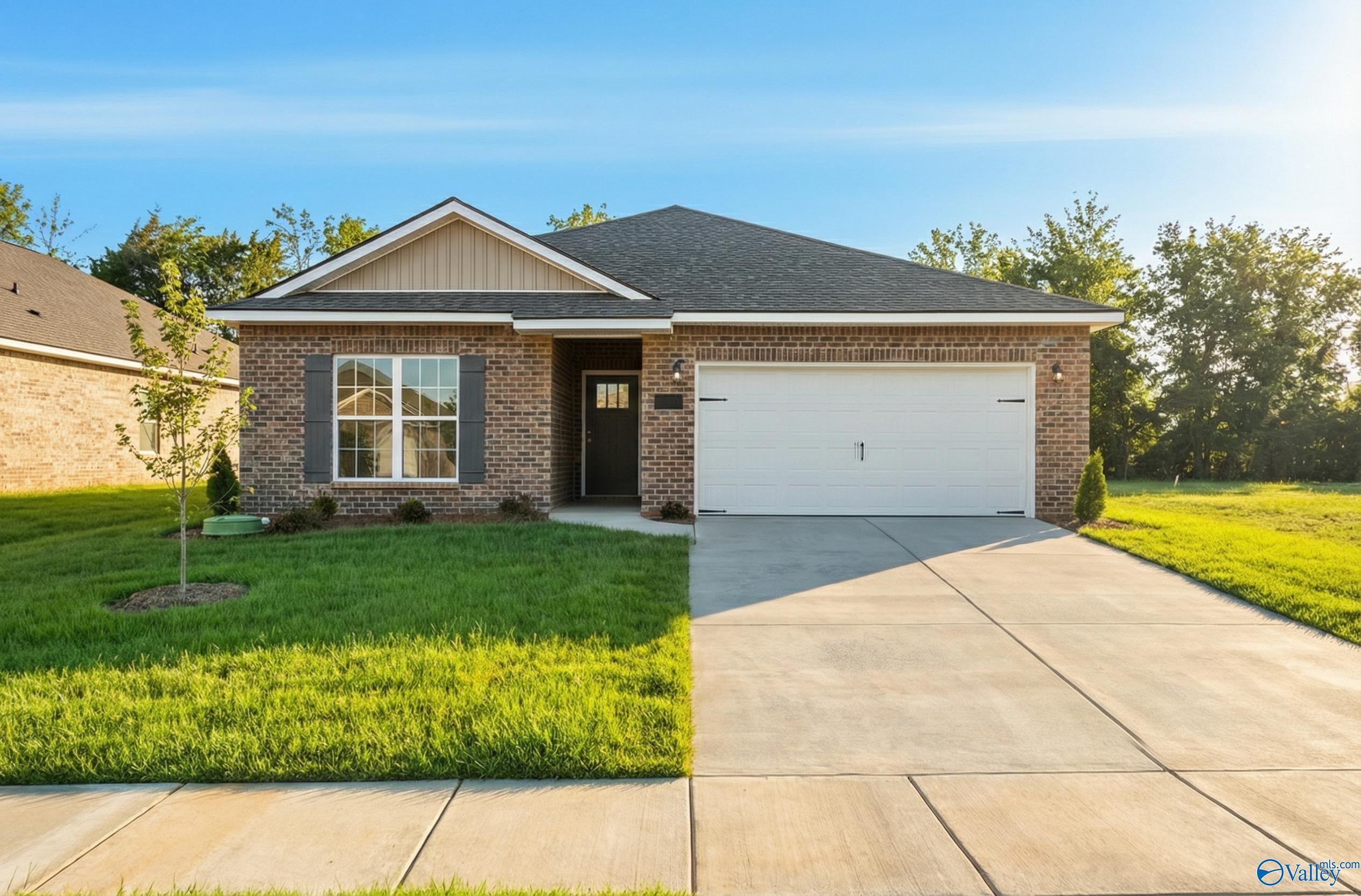 Brick single-story home with 2-car garage, green lawn, and trees in Lynn Meadows, Meridianville, Alabama by Davidson Homes