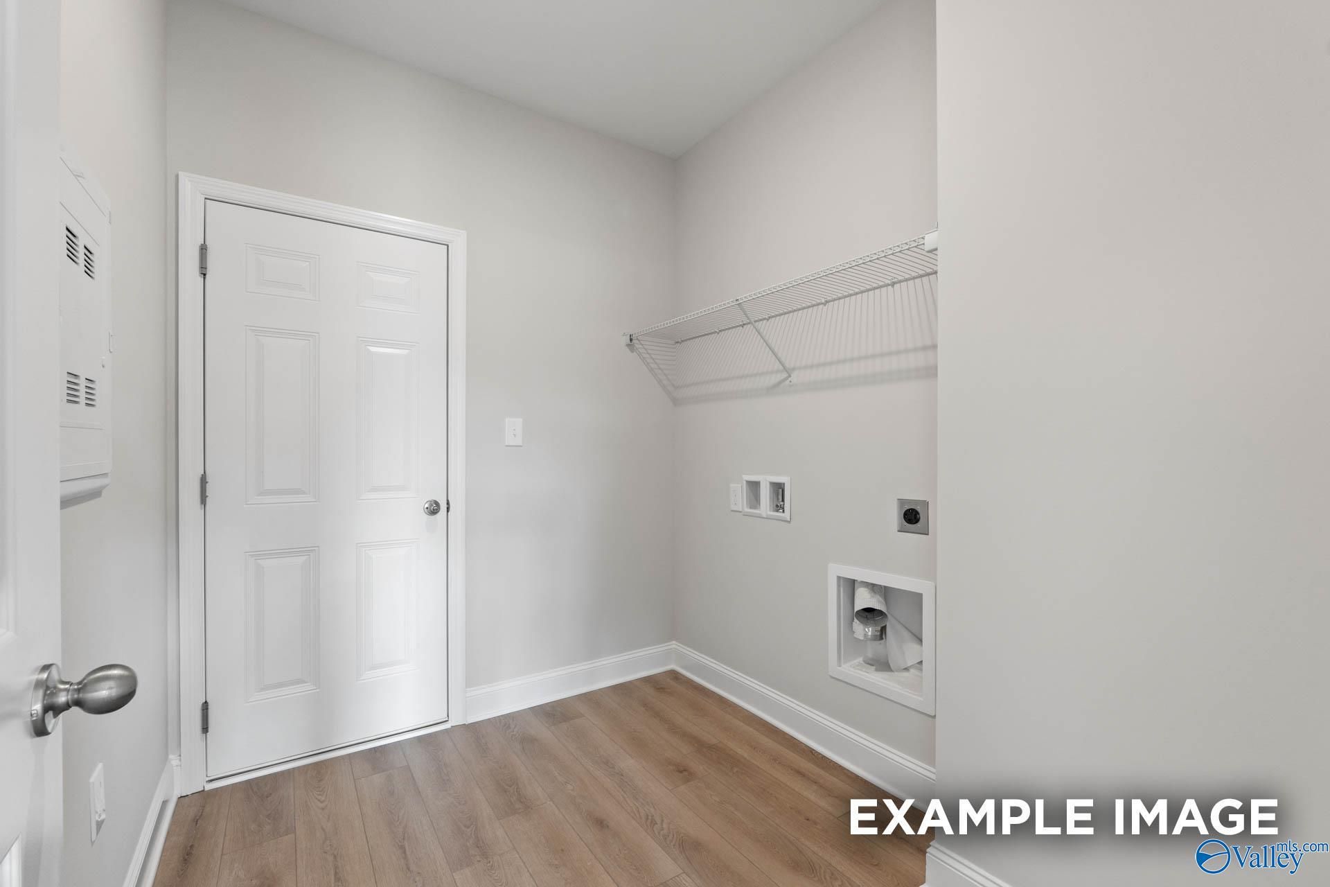 Functional laundry room featuring utility sink, wire shelving, and hardwood floors in Davidson Homes The Butler, Owens Cross Roads, Alabama
