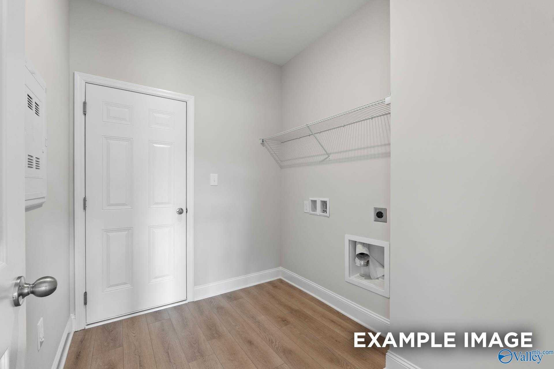 Modern laundry room with wire shelving, washer/dryer hookups, and hardwood floors in Davidson Homes The Butler, Huntsville AL