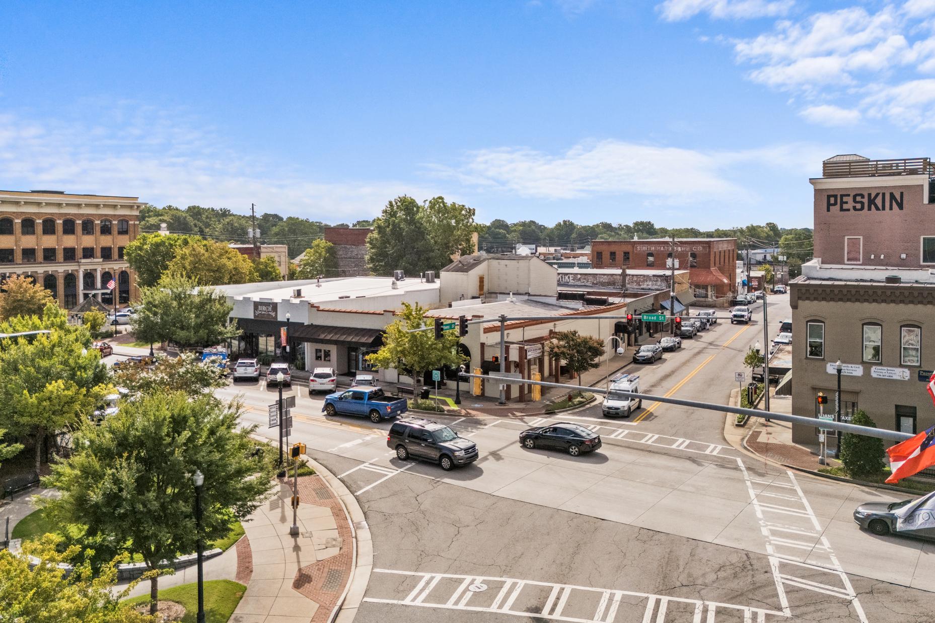 Historic downtown Winder Georgia intersection near Lake Shore community with brick buildings, trees, and American flags