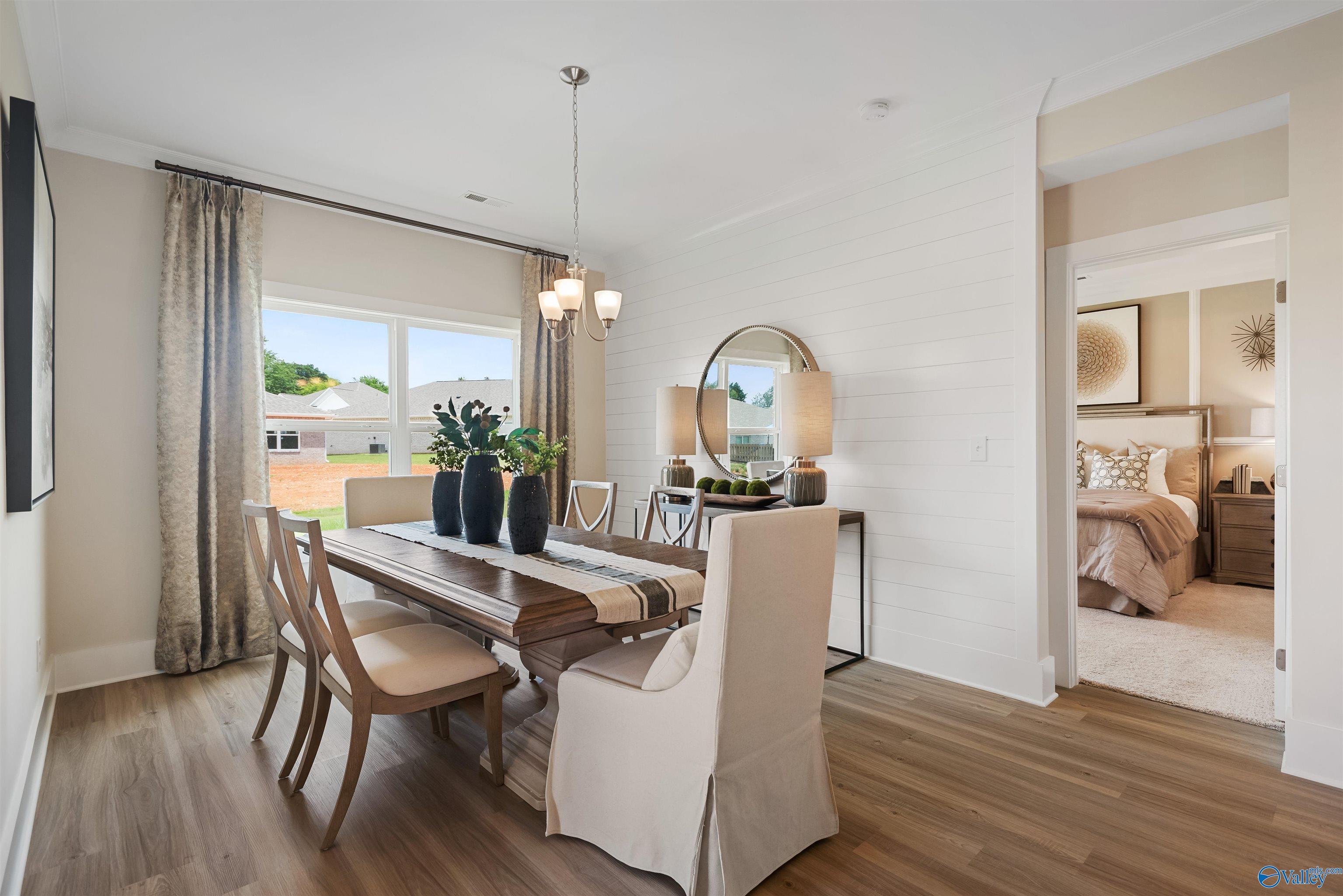 Elegant dining room featuring wooden table, chandelier, and adjacent bedroom in Davidson Homes The Everett, New Market, Alabama