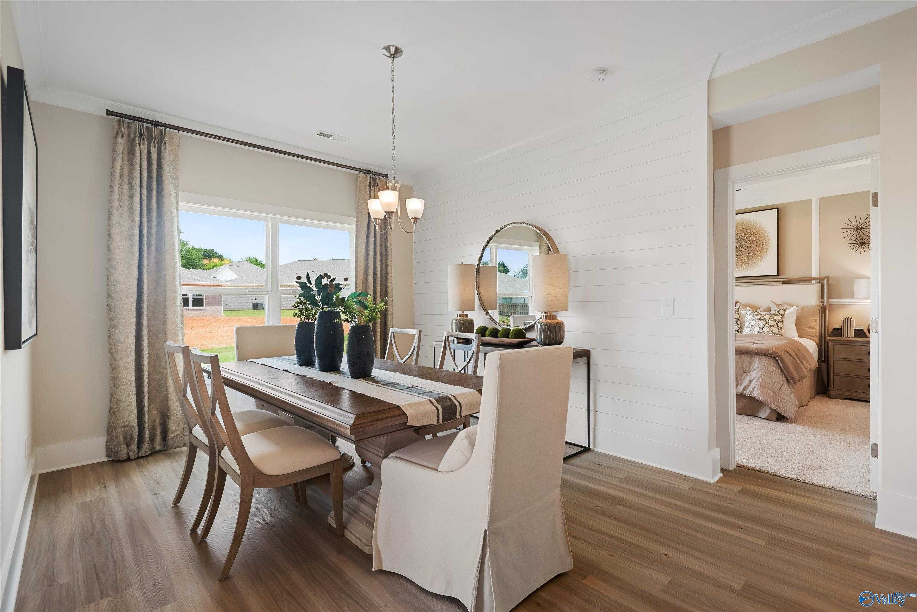 Elegant dining room featuring wooden table, chandelier, and adjacent bedroom in Davidson Homes The Everett, New Market, Alabama