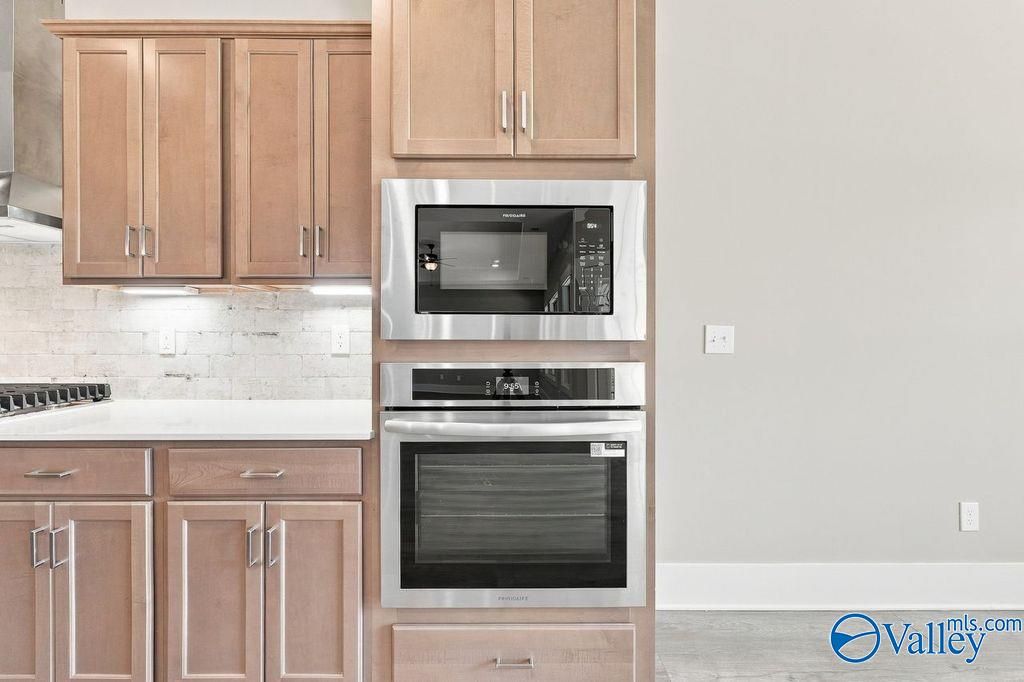 Modern kitchen with built-in stainless steel wall oven and microwave in The Rockford floor plan, Cain Park, Hartselle, AL.