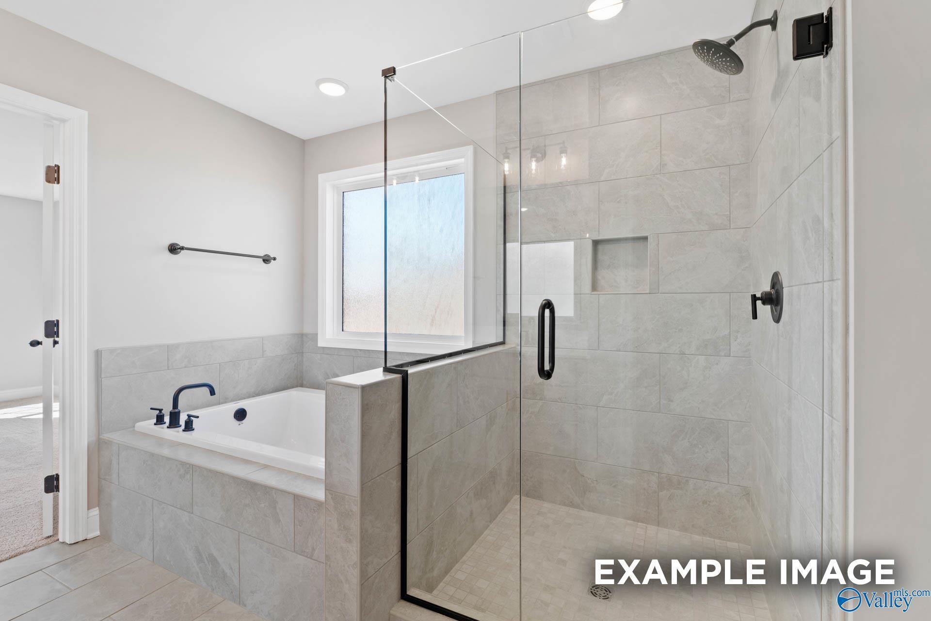 Modern master bathroom with a soaking tub and walk-in tiled shower in The Madison D floor plan, Evergreen Mill, Madison.