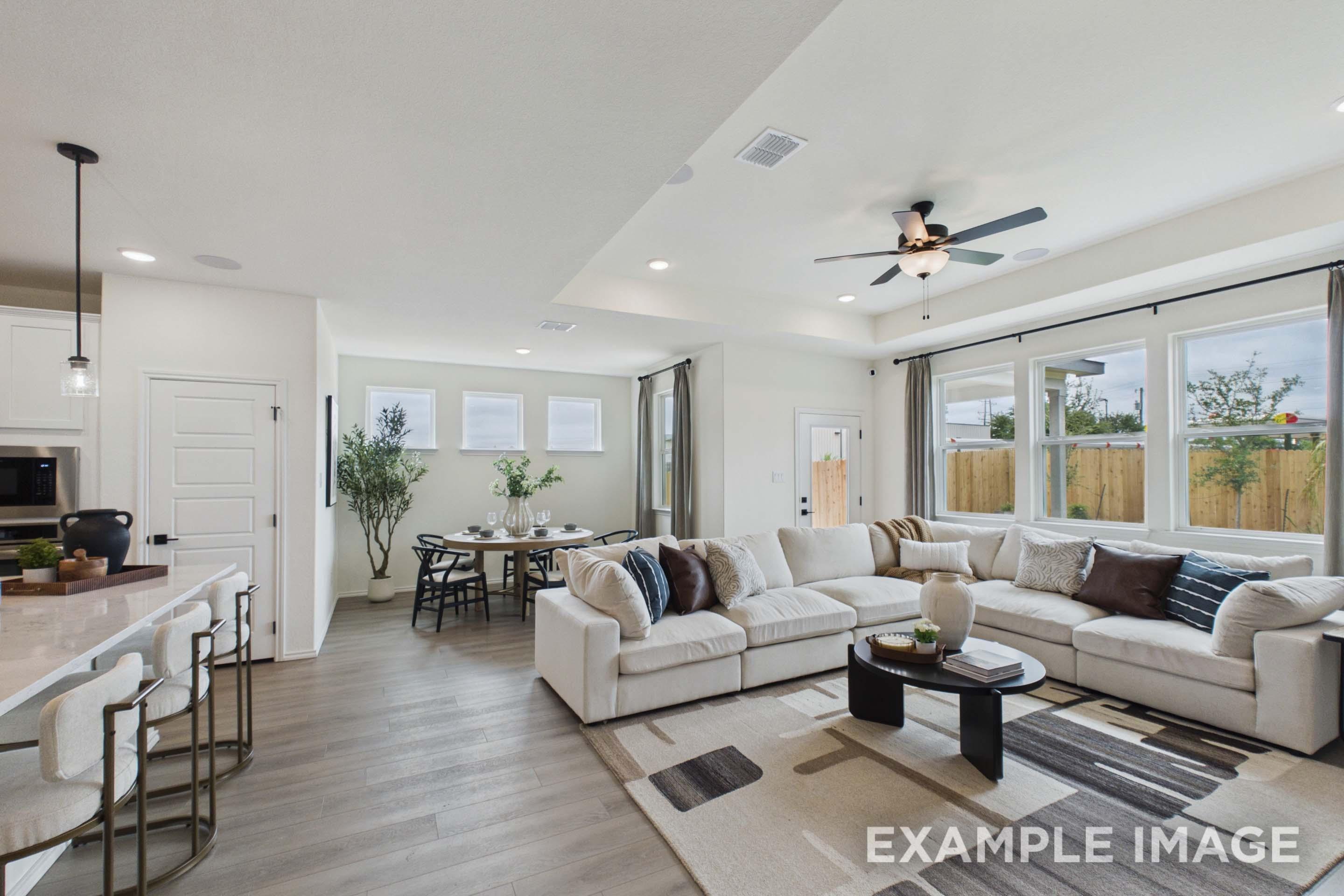 Open-concept living and dining area in The Laurel G floor plan featuring a spacious kitchen island and tray ceiling.