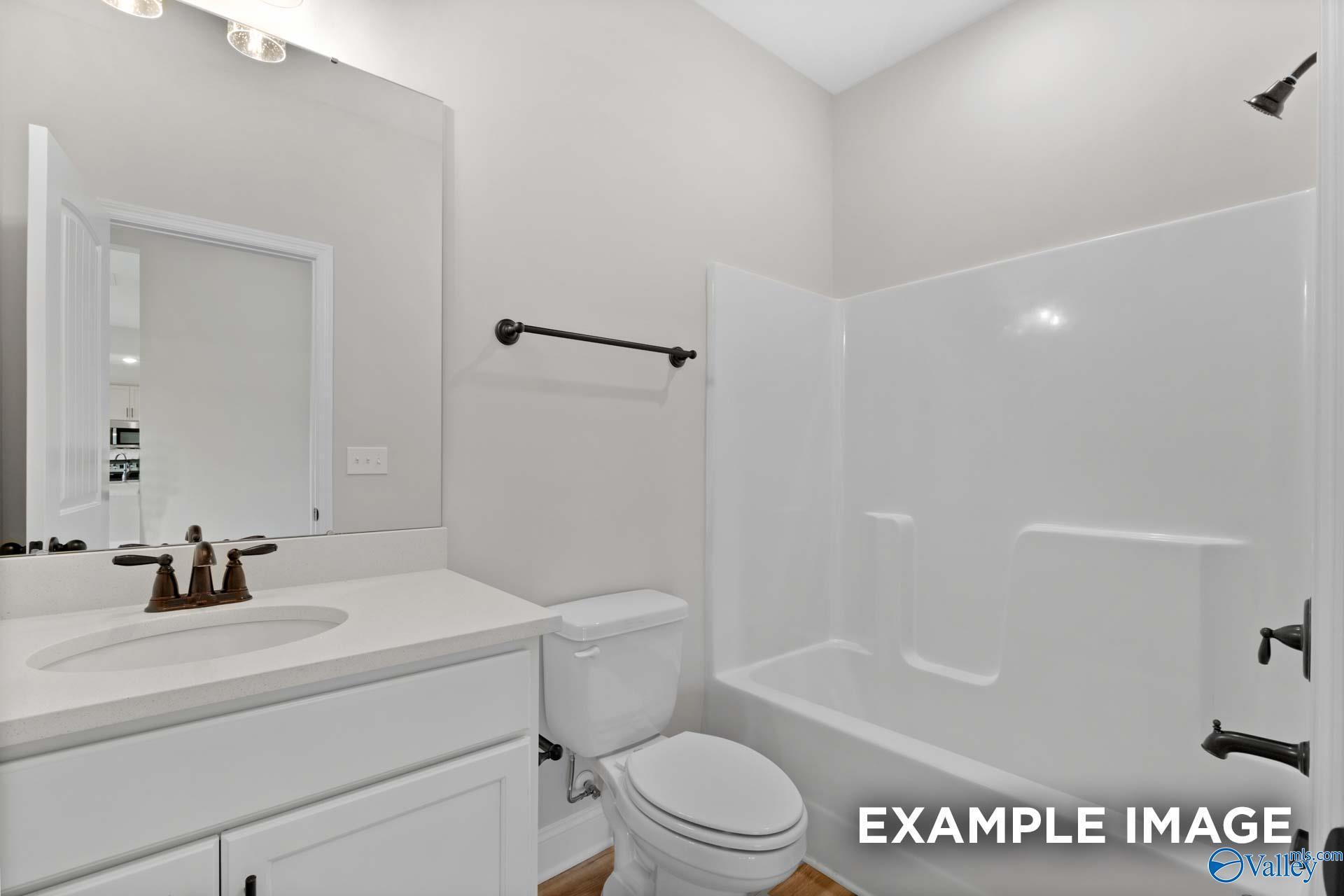 Modern bathroom with white vanity, quartz countertop, and tub-shower combo in Davidson Homes Shelby B, Jaguar Hills, AL.