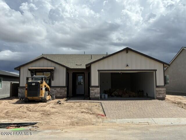 New construction single-story home with 3-car garage and paver driveway at South Ranch Western Collection, Prescott, Arizona
