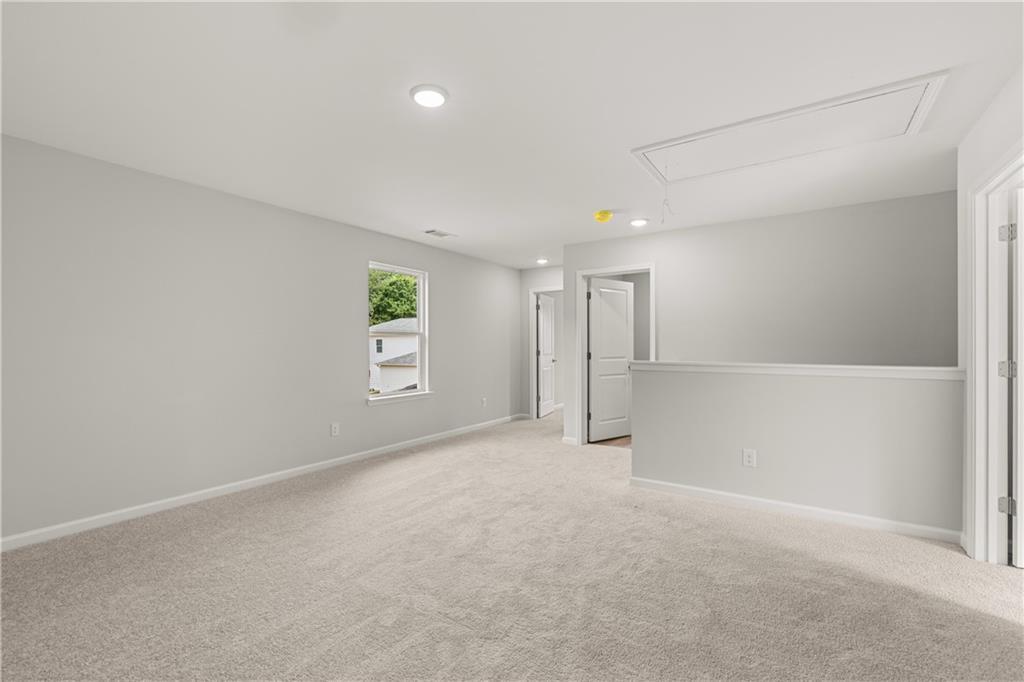 Spacious carpeted loft area in The Russell A floor plan at Cedar Farms in Winder, Georgia by Davidson Homes.