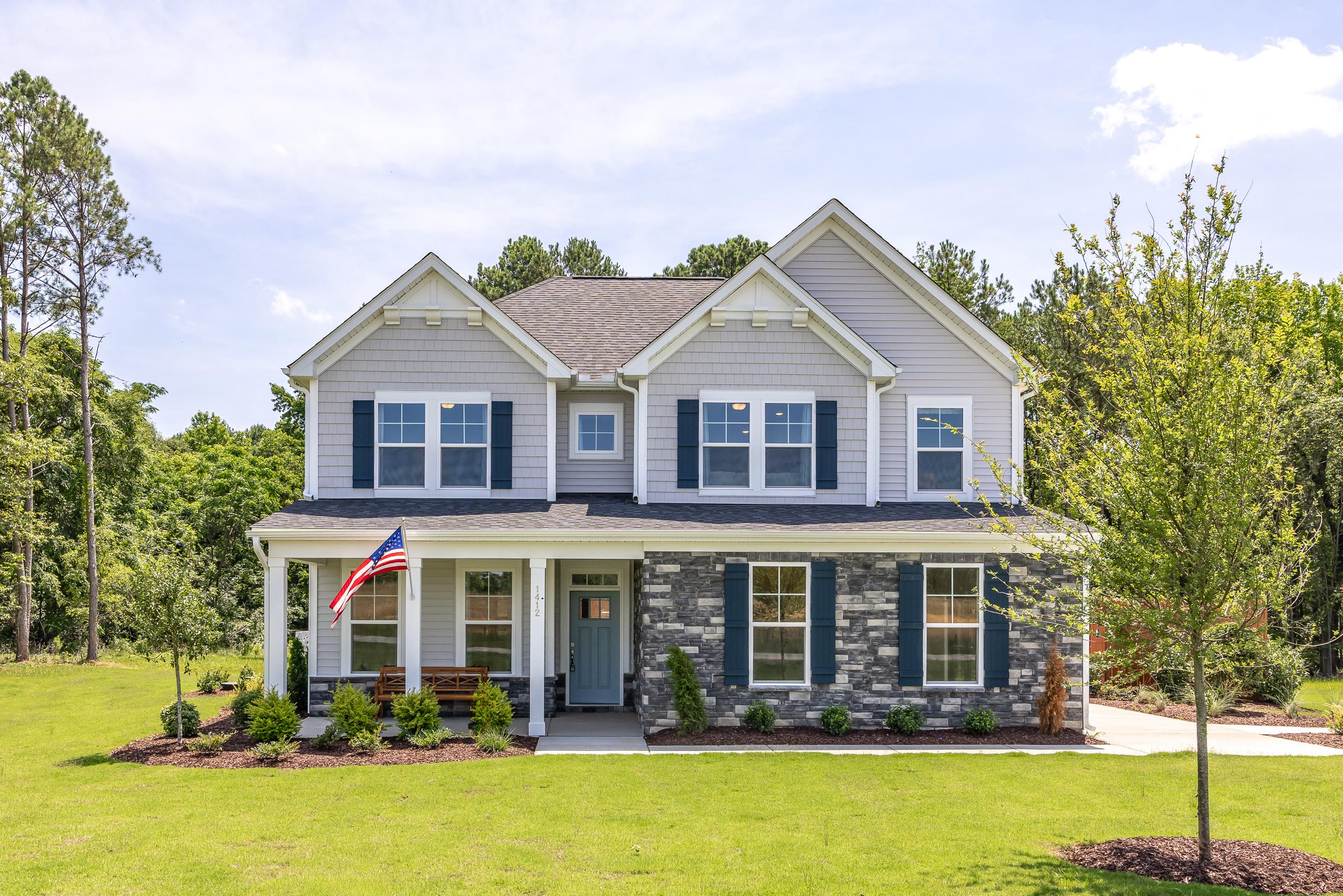 Modern two-story craftsman home exterior at Retreat at North Main in Lillington NC with covered porch and American flag